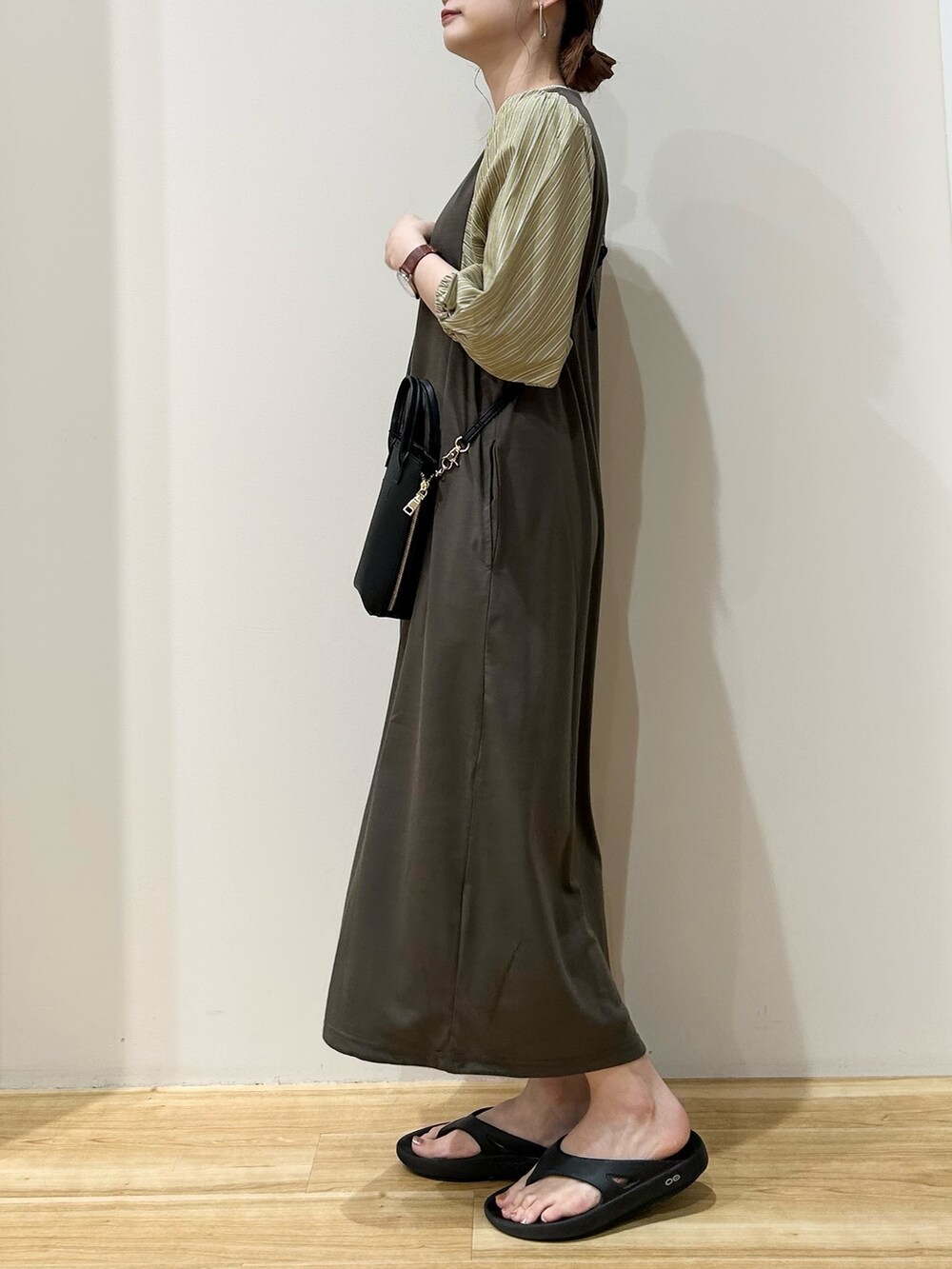 ブラック系のショルダーバッグ、ブラック系のサンダル、ブラウン系のワンピースを着用したレディースの夏コーディネートの2枚目の写真