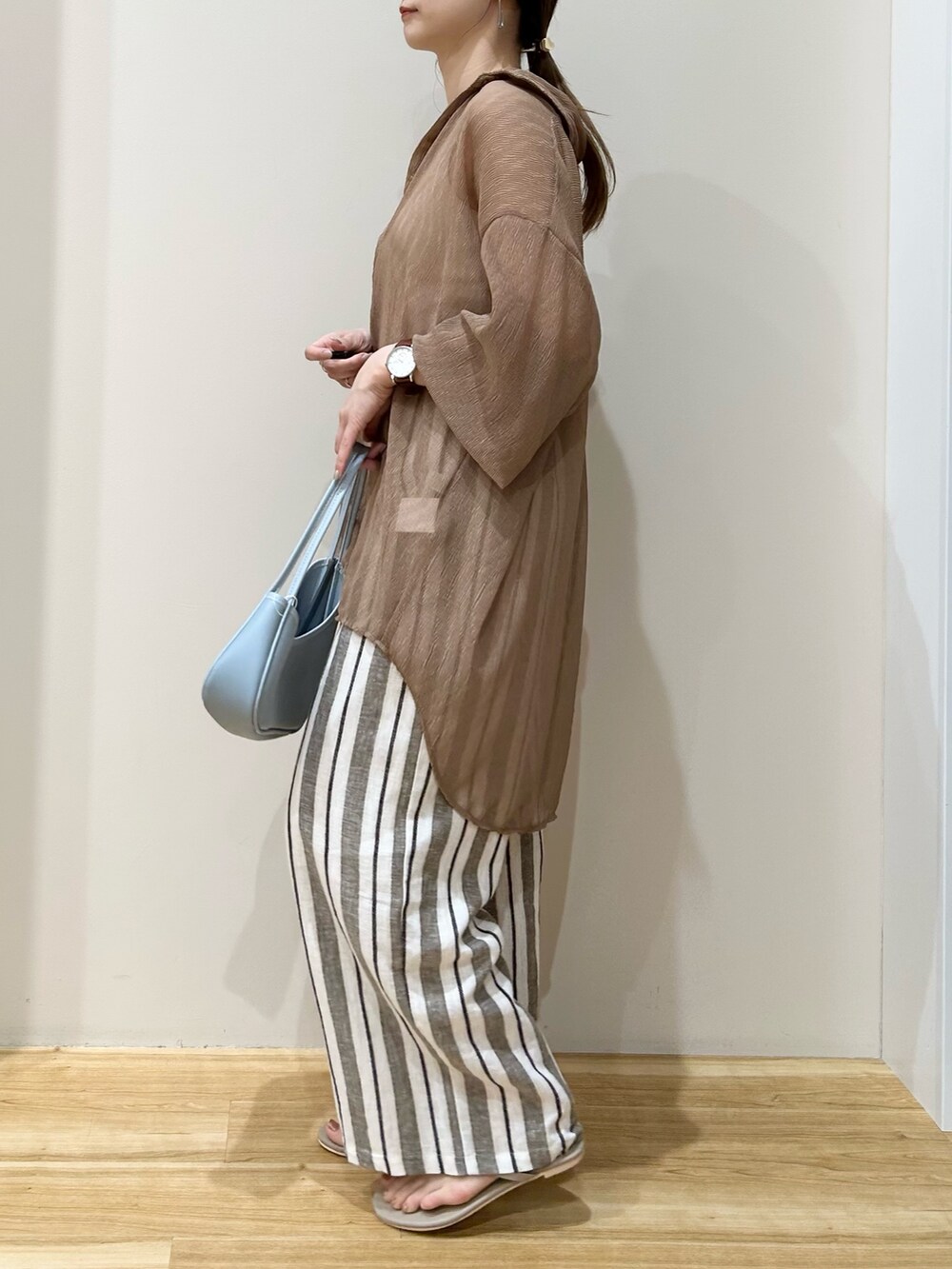 ベージュ系のシャツ/ブラウス、その他のその他パンツ、ブルー系のハンドバッグを着用したレディースの夏コーディネートの2枚目の写真