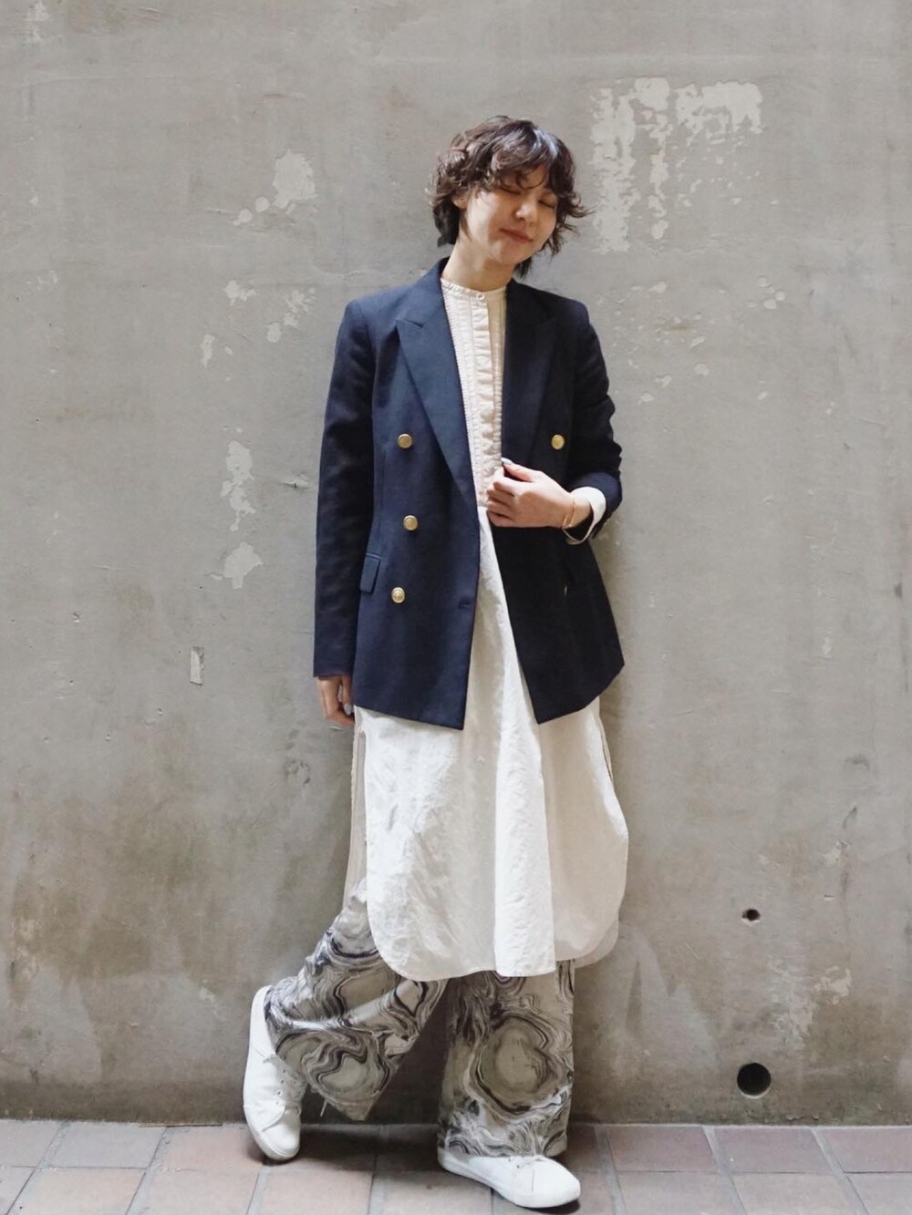 ブルー系のテーラードジャケット、ピンク系のシャツワンピース、ホワイト系のスニーカーを着用したレディースの春コーディネートの2枚目の写真