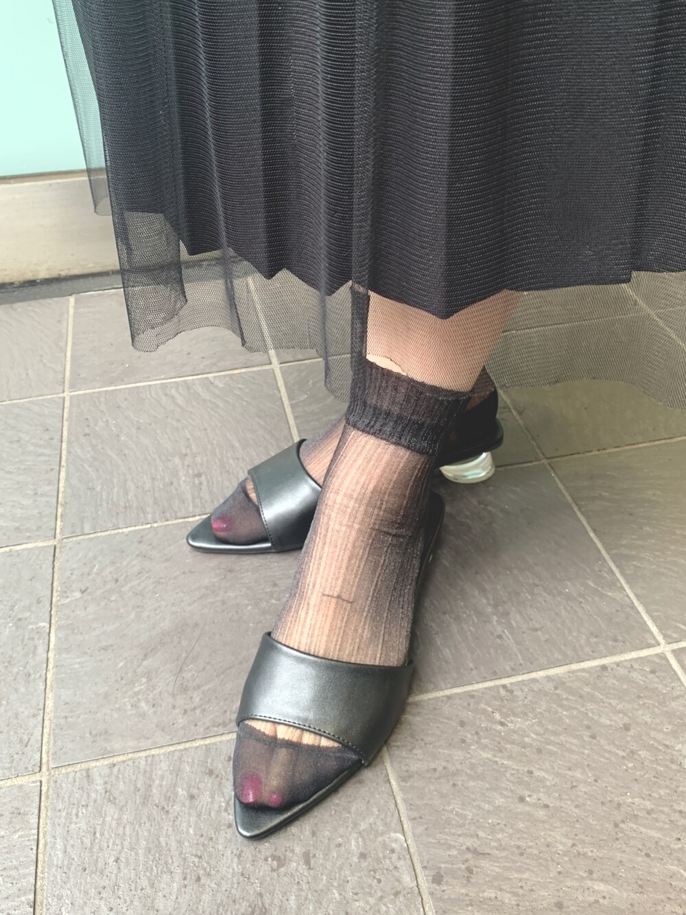 ブラック系のサンダル、ブラック系のスカート、ホワイト系のTシャツ/カットソーを着用したレディースの夏コーディネートの2枚目の写真