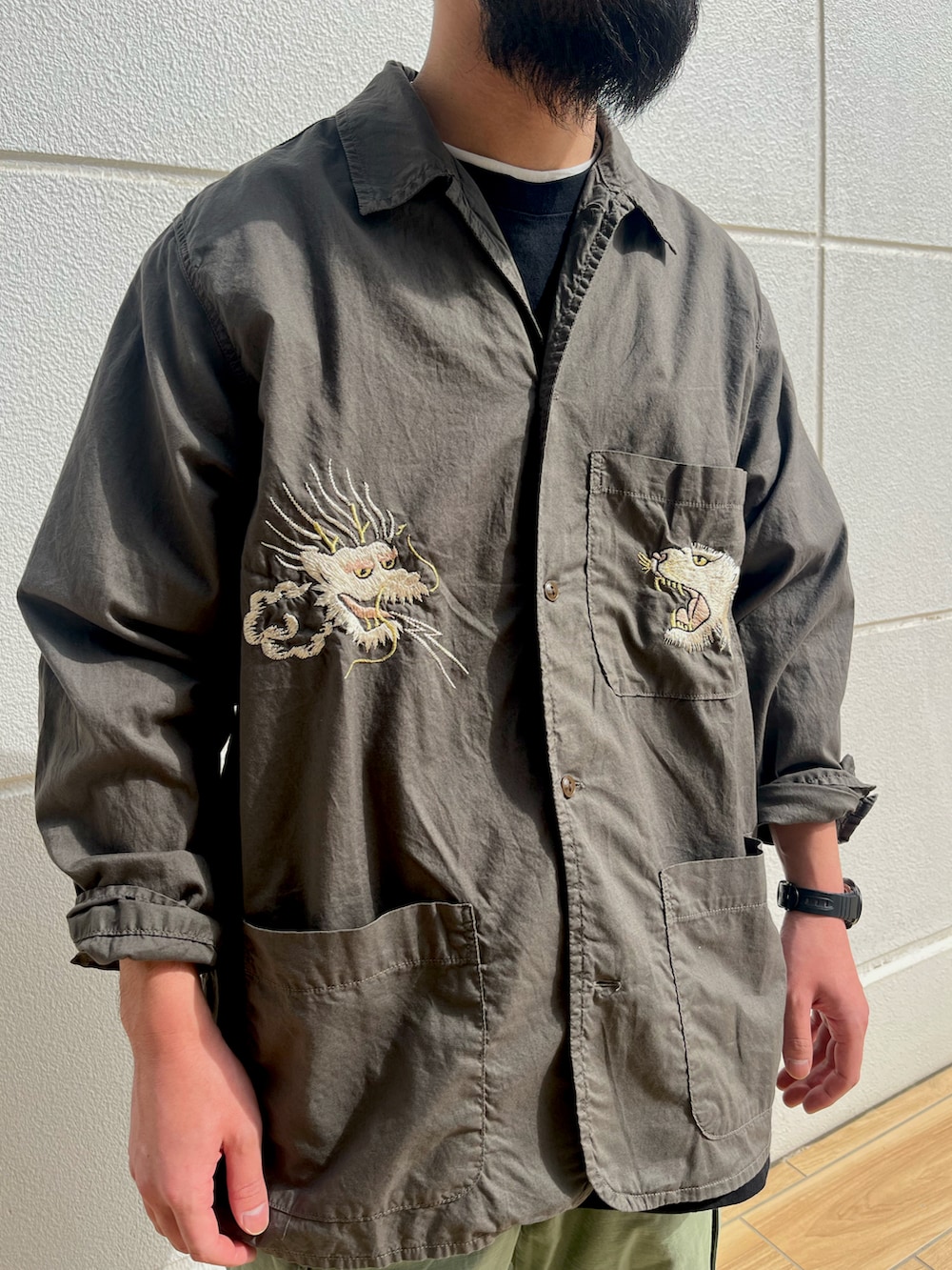 ブラック系のTシャツ/カットソー、グリーン系のカーゴパンツ、グリーン系のカバーオールを着用したメンズの春コーディネートの2枚目の写真