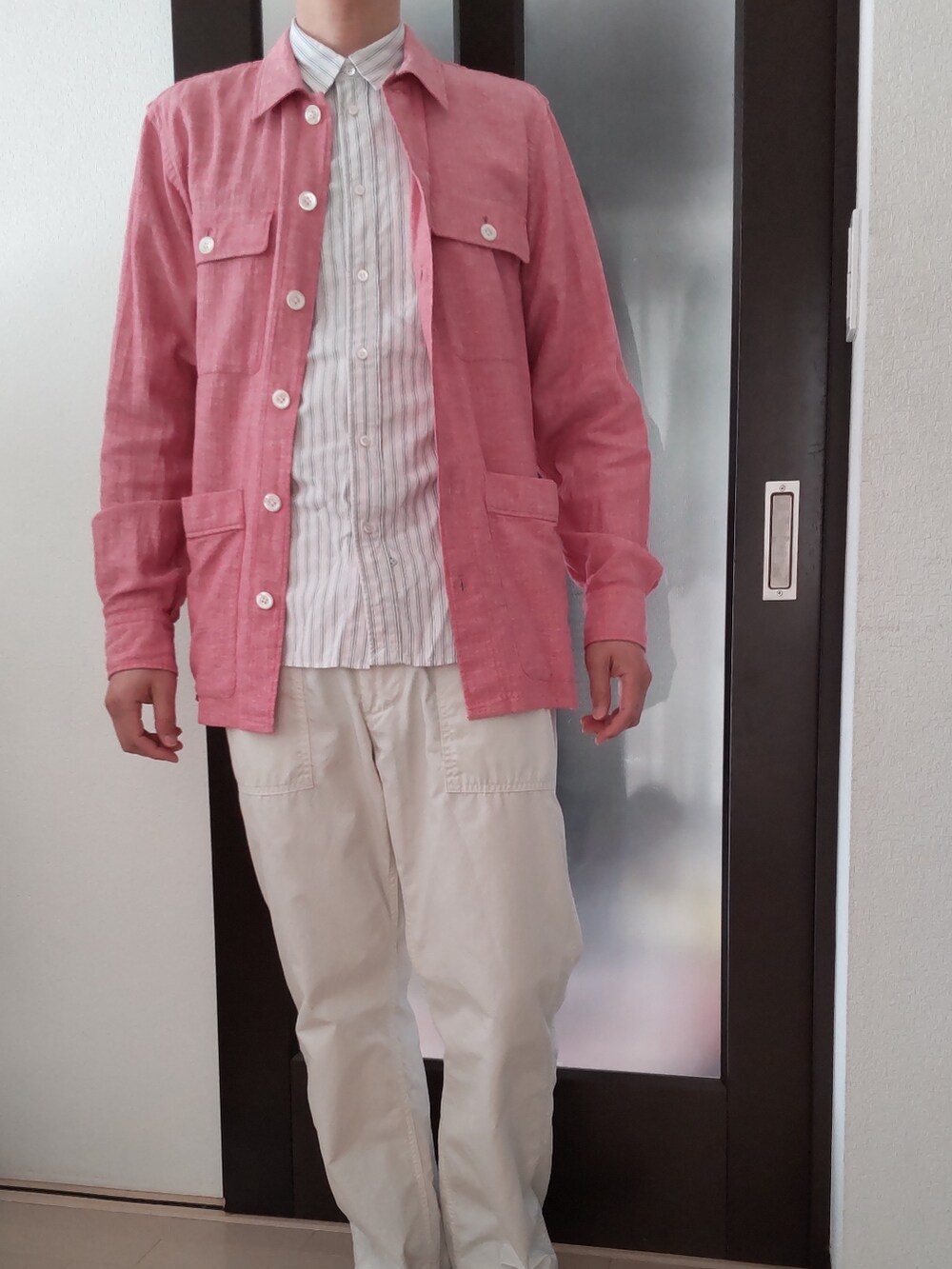 ホワイト系のパンツ、レッド系のミリタリージャケット、ピンク系のシャツ/ブラウスを着用したメンズの春コーディネートの2枚目の写真