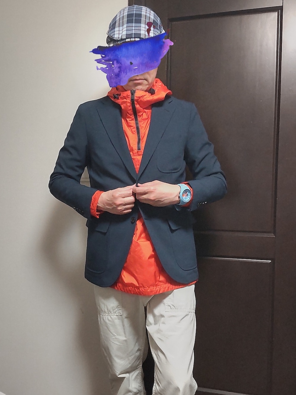 オレンジ系のマウンテンパーカー、ブルー系のテーラードジャケット、ホワイト系のパンツを着用したメンズの春コーディネートの2枚目の写真