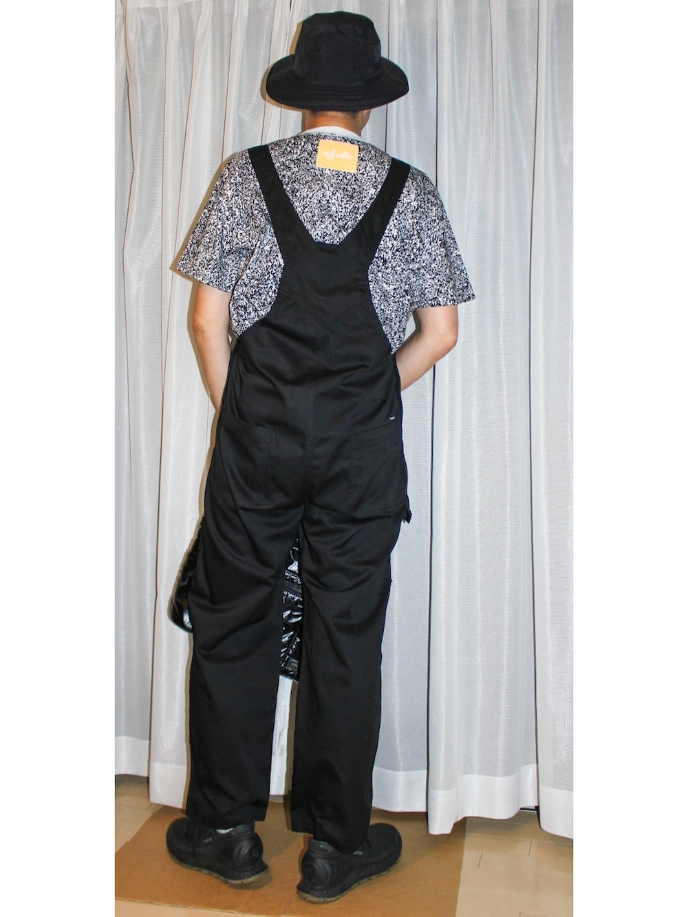 ブラック系のトートバッグ、ブラック系のサロペット/オーバーオール、その他のTシャツ/カットソーを着用したメンズの秋コーディネートの2枚目の写真