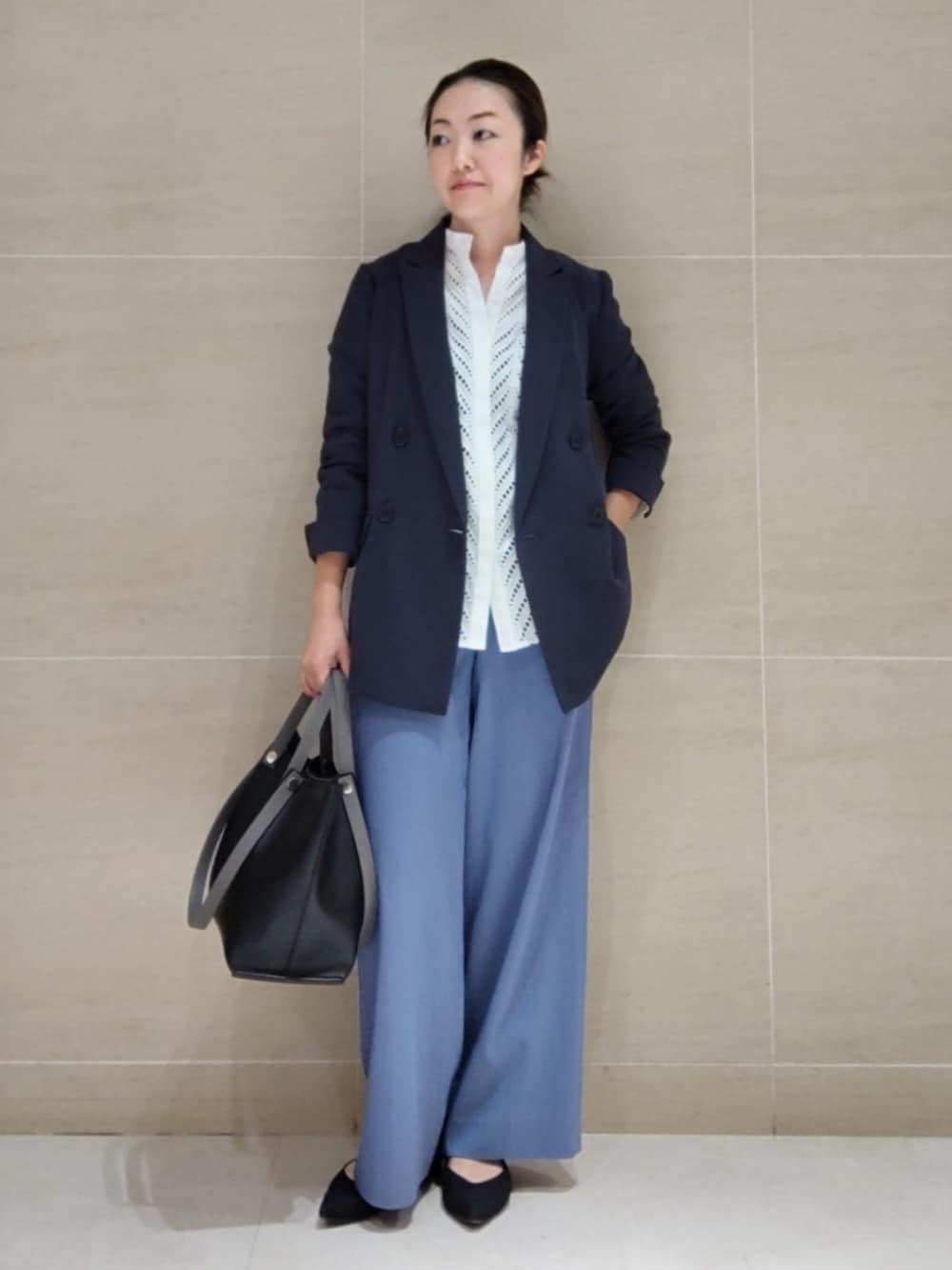 グレー系のスーツジャケット、ホワイト系のシャツ/ブラウス、ブルー系のその他パンツを着用したレディースの春コーディネートの2枚目の写真