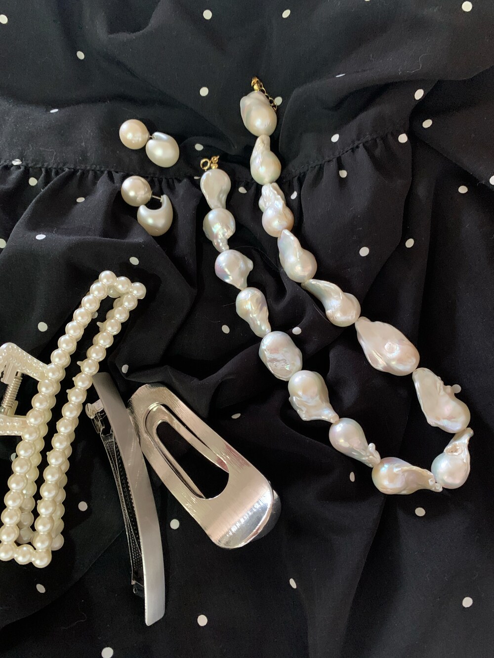 ブラック系のスカート、ホワイト系のシャツ/ブラウス、ブラック系のブーツを着用したレディースの夏コーディネートの3枚目の写真