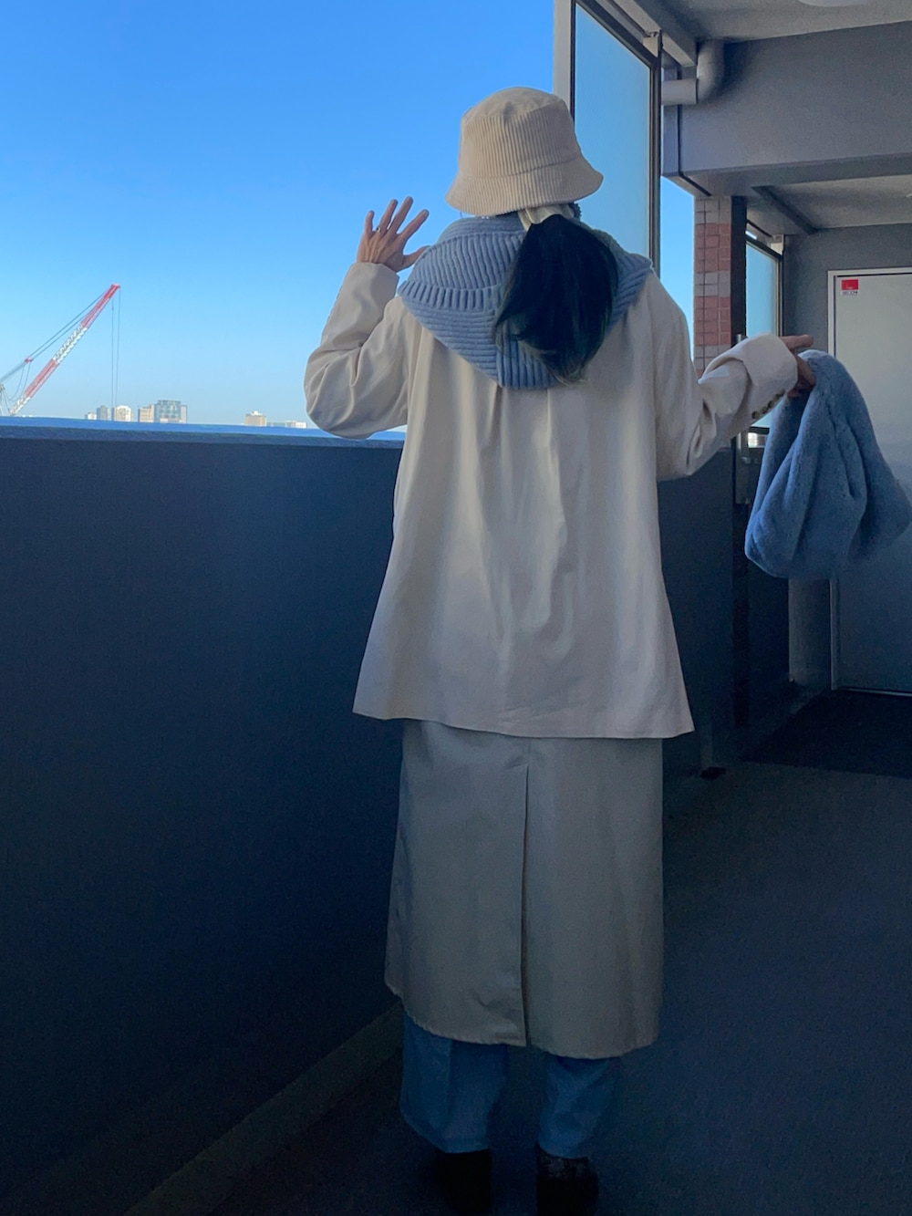 ブルー系のパンツ、ブルー系のトートバッグ、その他のブーツを着用したレディースの冬コーディネートの2枚目の写真