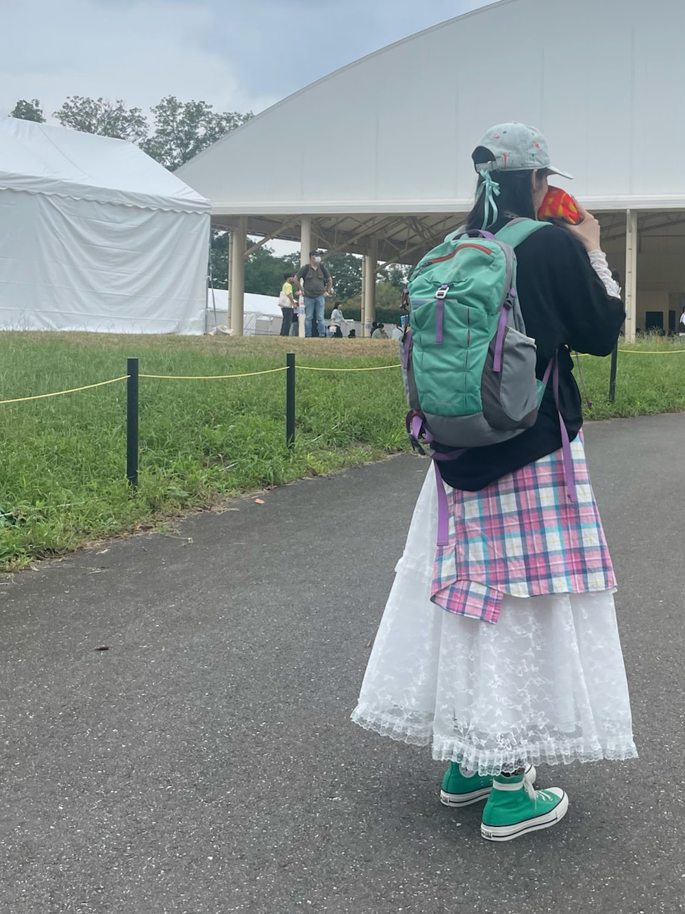 ホワイト系のスカート、ピンク系のシャツ/ブラウス、グリーン系のスニーカーを着用したレディースの秋コーディネートの2枚目の写真