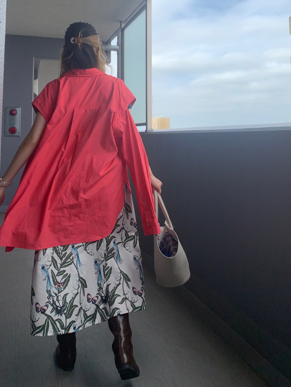 ホワイト系のショルダーバッグ、ホワイト系のスカート、ブラウン系のブーツを着用したレディースの秋コーディネートの2枚目の写真