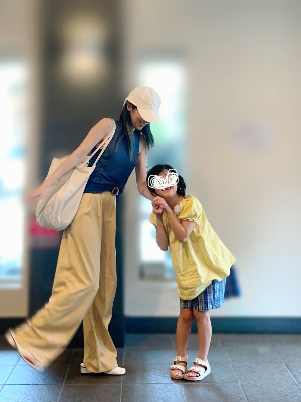 ブルー系のタンクトップ、イエロー系のパンツ、ホワイト系のサンダルを着用したレディースの夏コーディネートの2枚目の写真
