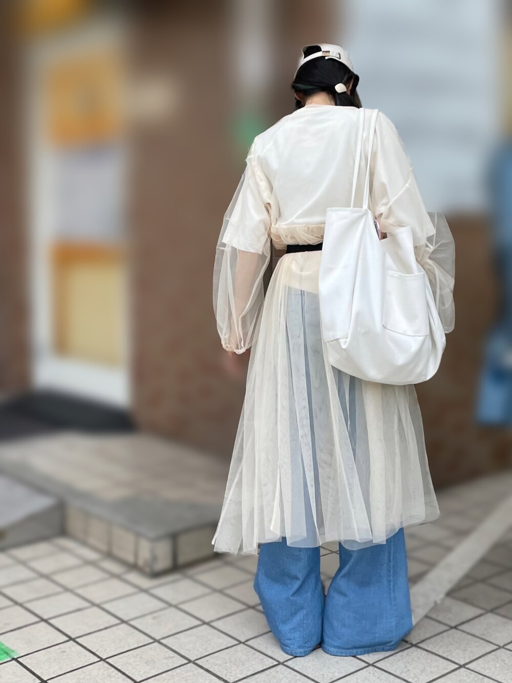 ホワイト系のワンピース、ホワイト系のTシャツ/カットソー、ブルー系のデニムパンツを着用したレディースの秋コーディネートの2枚目の写真