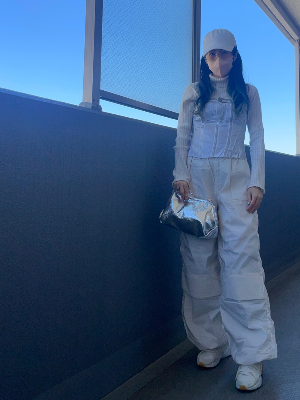 シルバー系のその他トップス、ホワイト系のカーゴパンツ、シルバー系のクラッチバッグを着用したレディースの春コーディネートの2枚目の写真