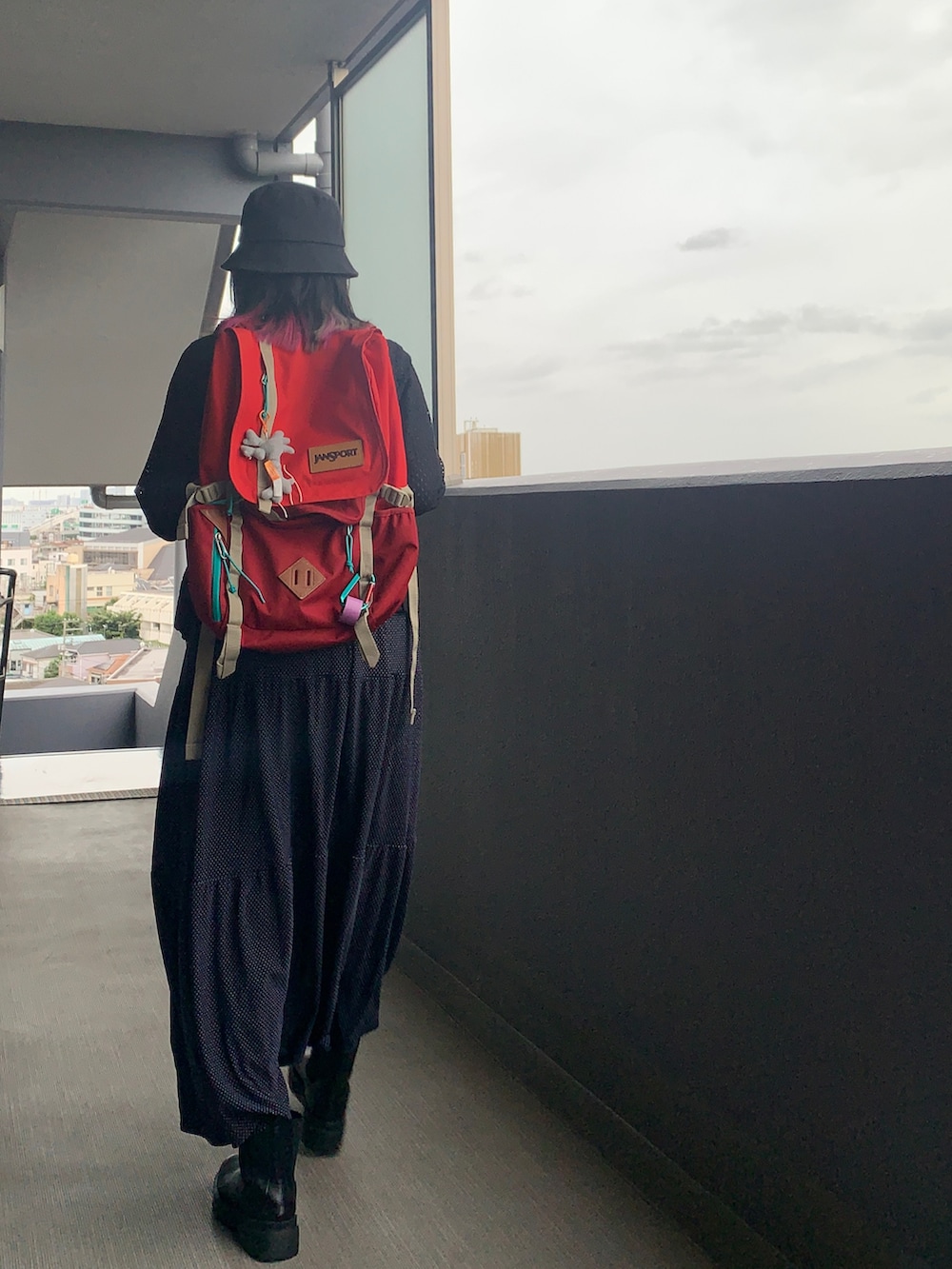 ブルー系のドレス、ブラック系のブーツ、ブラック系のブルゾンを着用したレディースの秋コーディネートの2枚目の写真