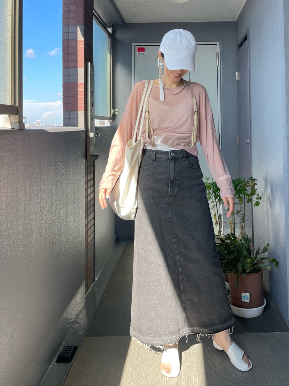 ピンク系のTシャツ/カットソー、ブラック系のキャミソール、グレー系のデニムスカートを着用したレディースの秋コーディネートの2枚目の写真