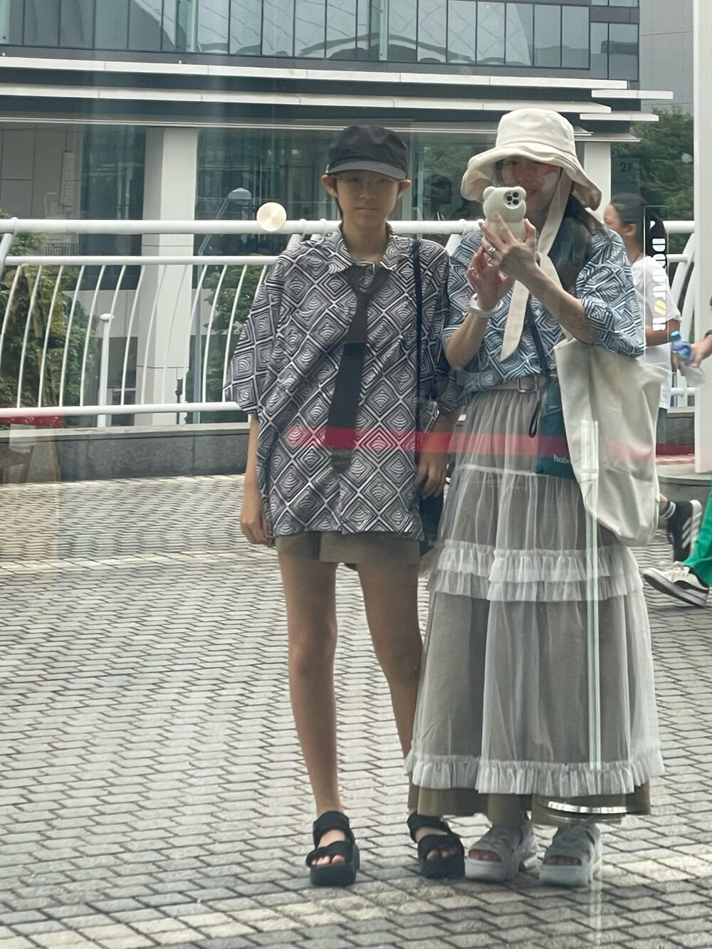 ブルー系のシャツ/ブラウス、ベージュ系のスカート、ホワイト系のサンダルを着用したレディースの夏コーディネートの2枚目の写真