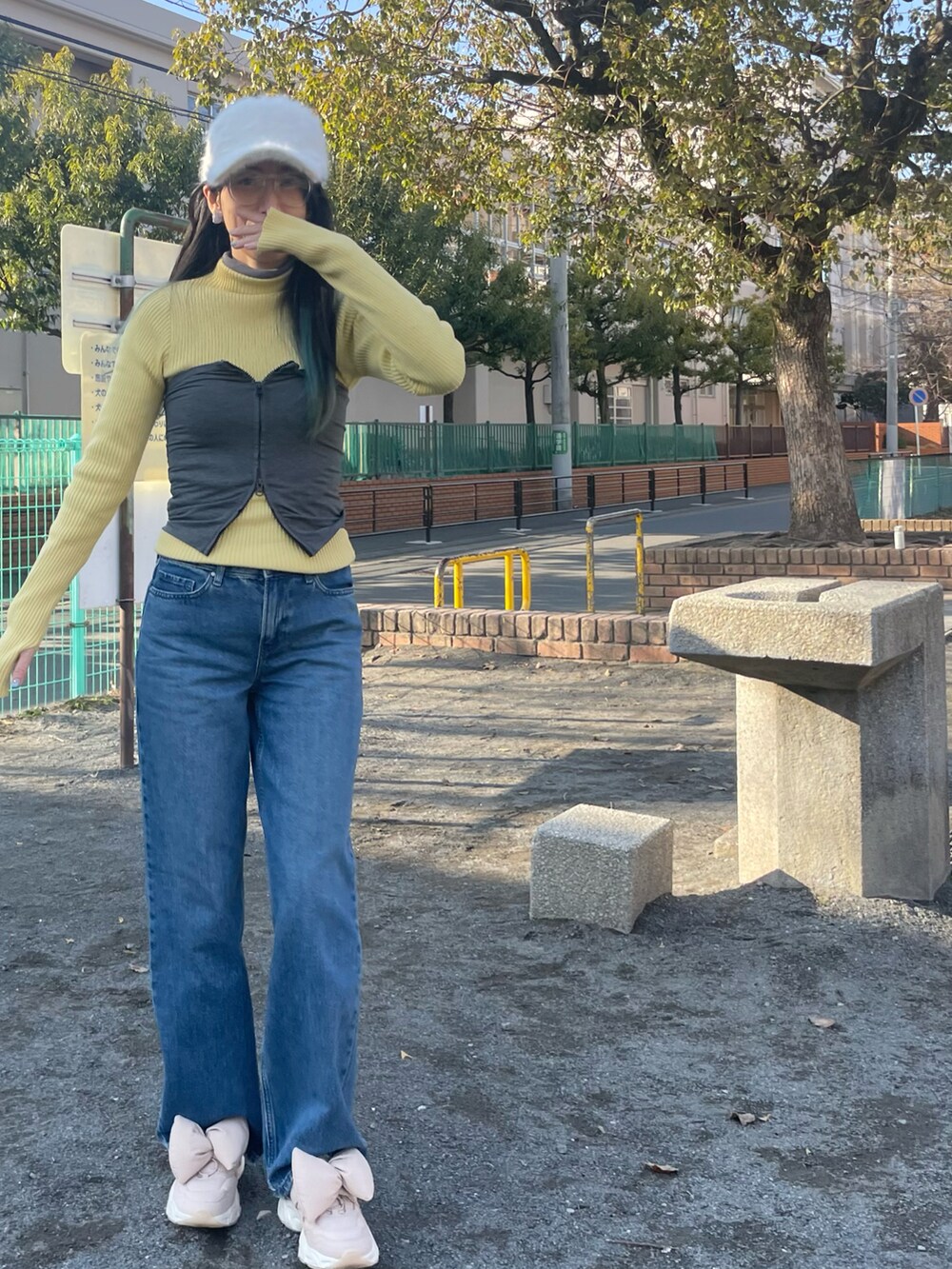グレー系のチューブトップ、ピンク系のニット/セーター、ブルー系のデニムパンツを着用したレディースの冬コーディネートの2枚目の写真