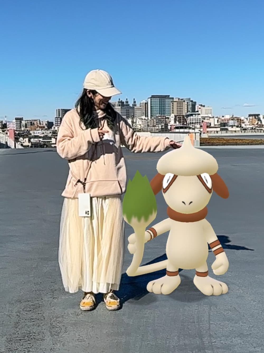 ベージュ系のパーカー、ホワイト系のワンピース、ホワイト系のスカートを着用したレディースの冬コーディネートの2枚目の写真