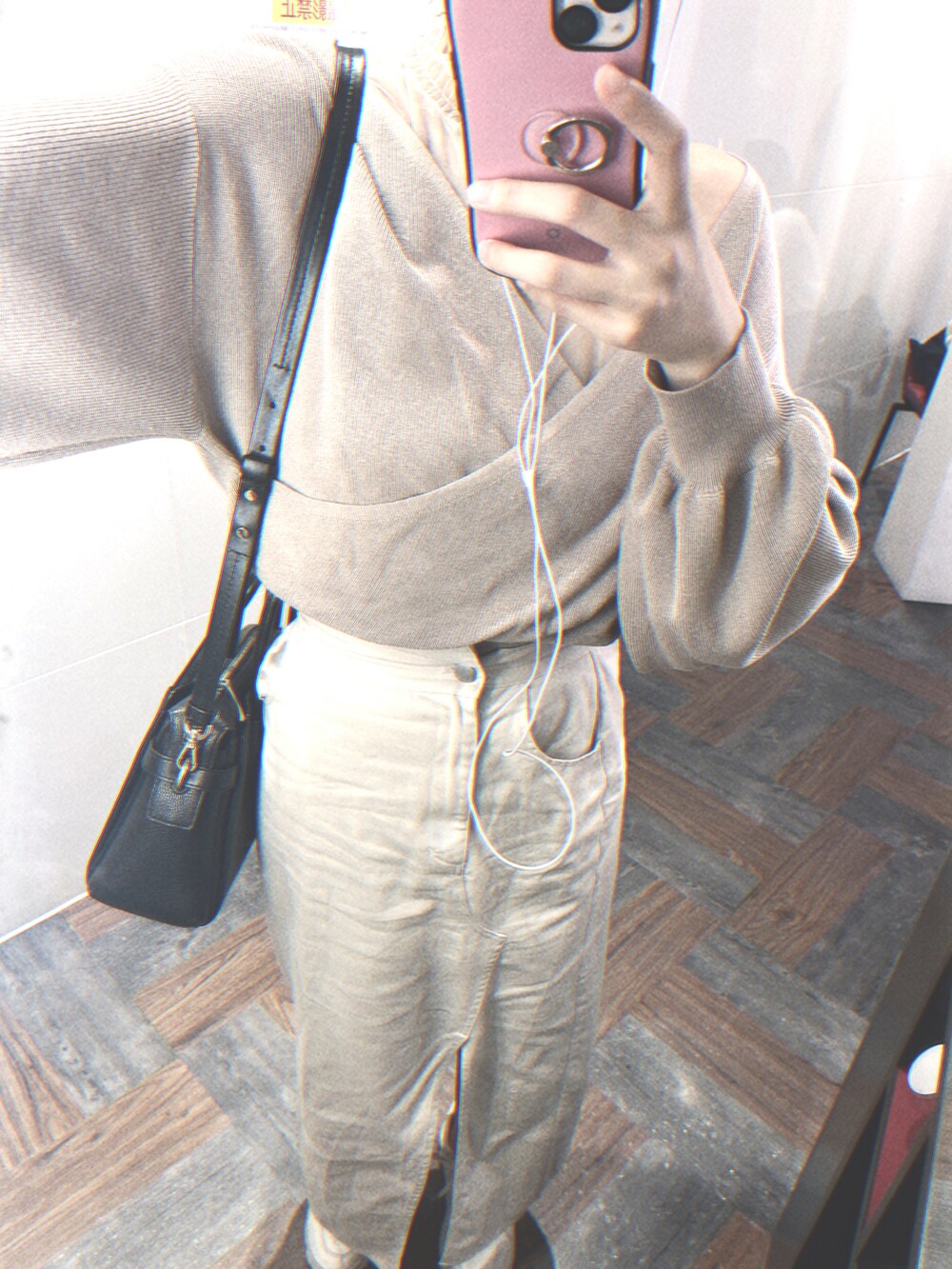 ベージュ系のスカート、ピンク系のトップス、ブラック系のバッグを着用したレディースの春コーディネートの2枚目の写真