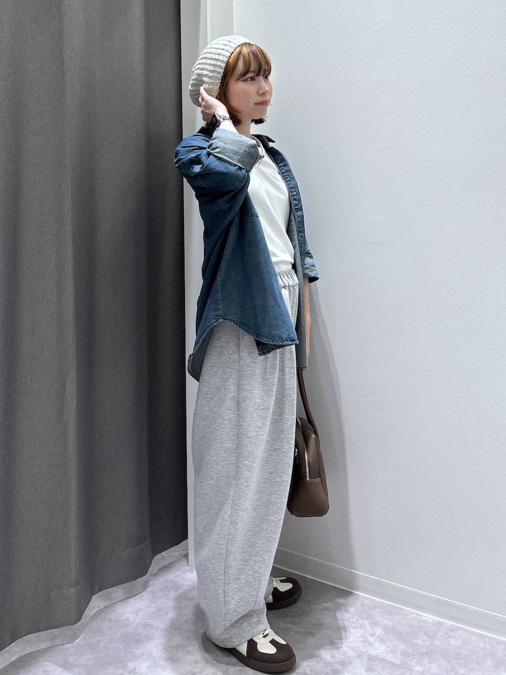 ブルー系のシャツ/ブラウス、ホワイト系のスニーカー、ブラウン系のボストンバッグを着用したレディースの秋コーディネートの2枚目の写真