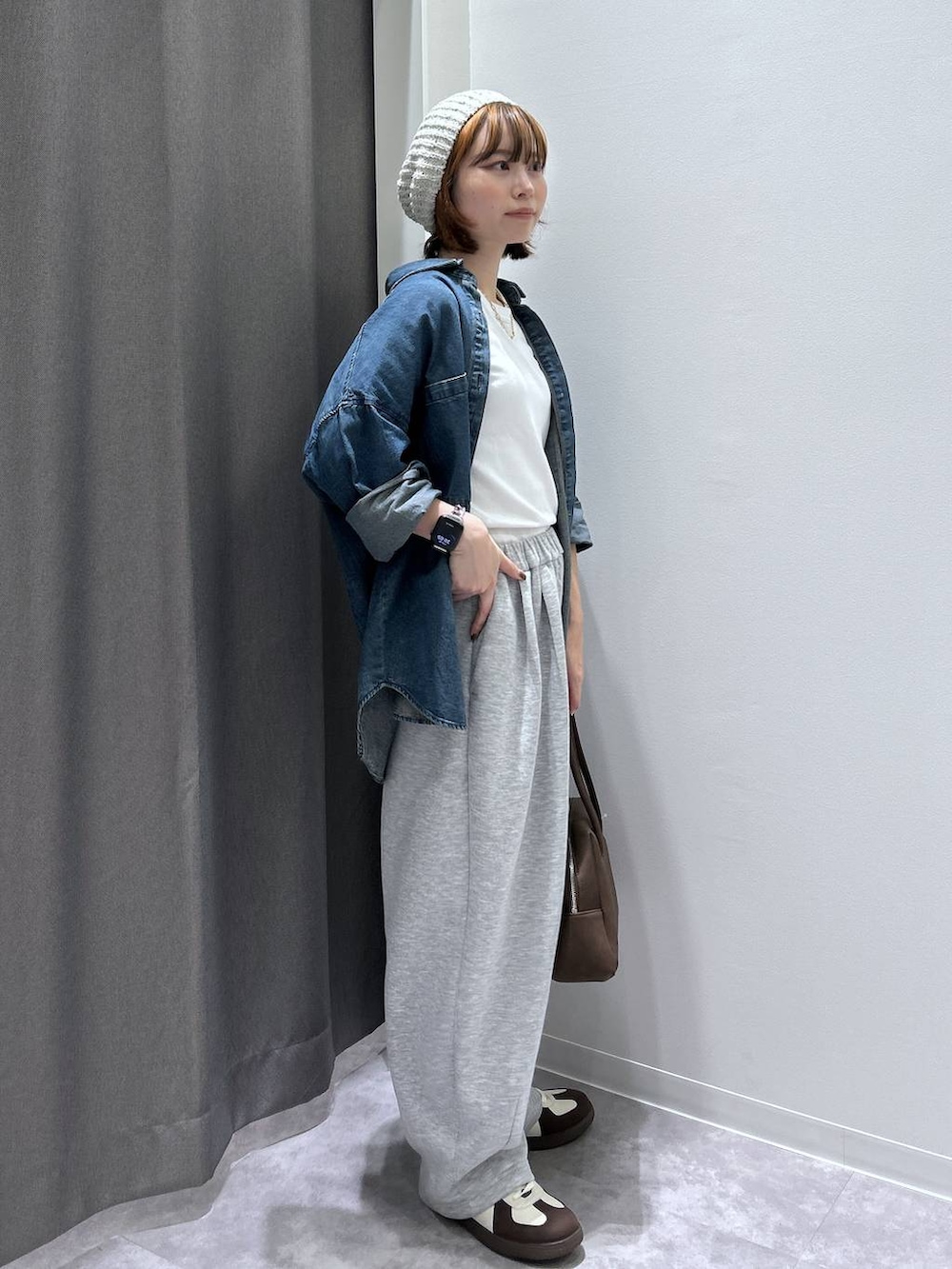 ブルー系のシャツ/ブラウス、ホワイト系のスニーカー、ブラウン系のボストンバッグを着用したレディースの秋コーディネートの5枚目の写真