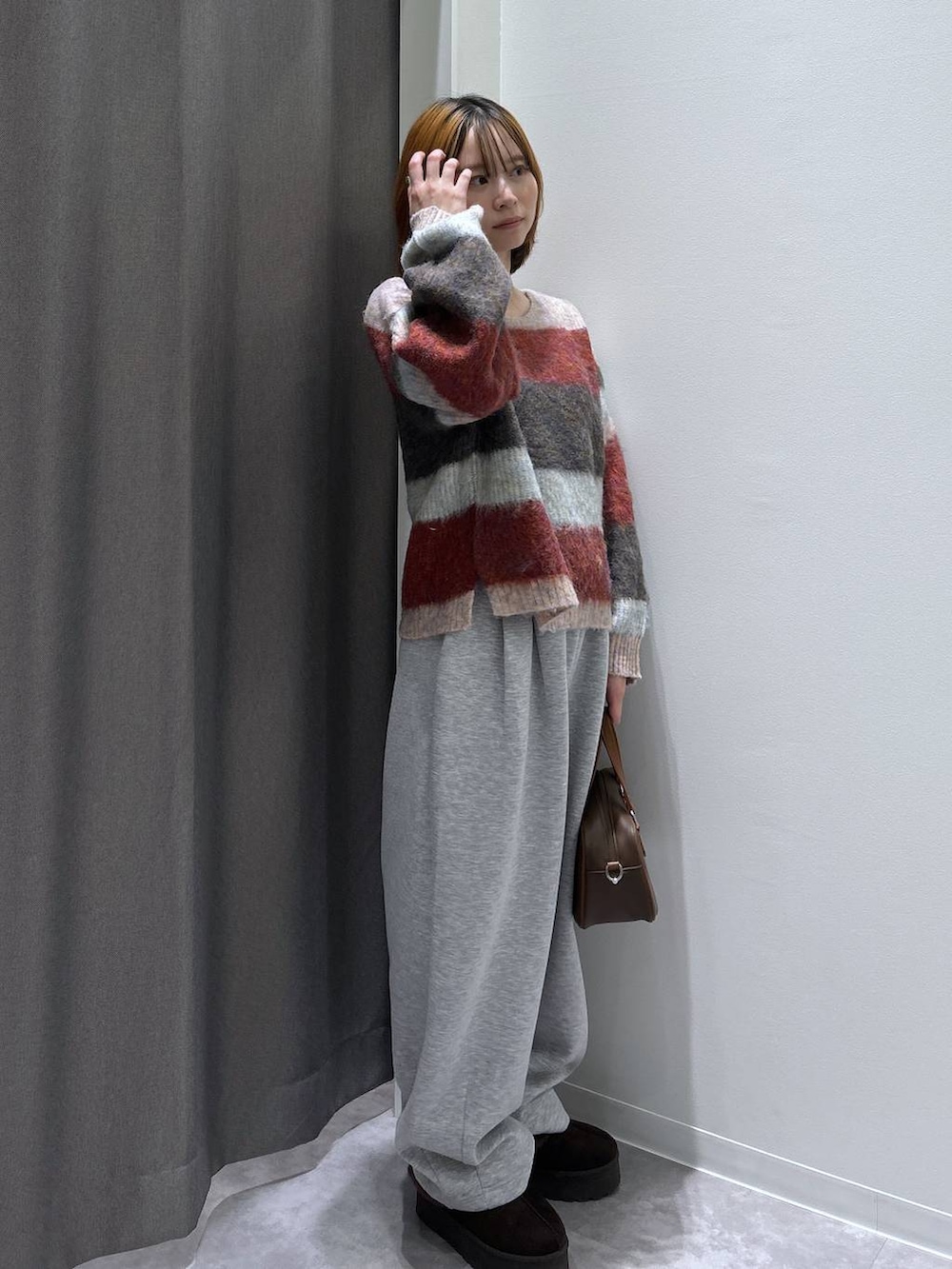 ブラウン系のスリッポン、グレー系のスウェットパンツ、ブラウン系のショルダーバッグを着用したレディースの秋コーディネートの3枚目の写真