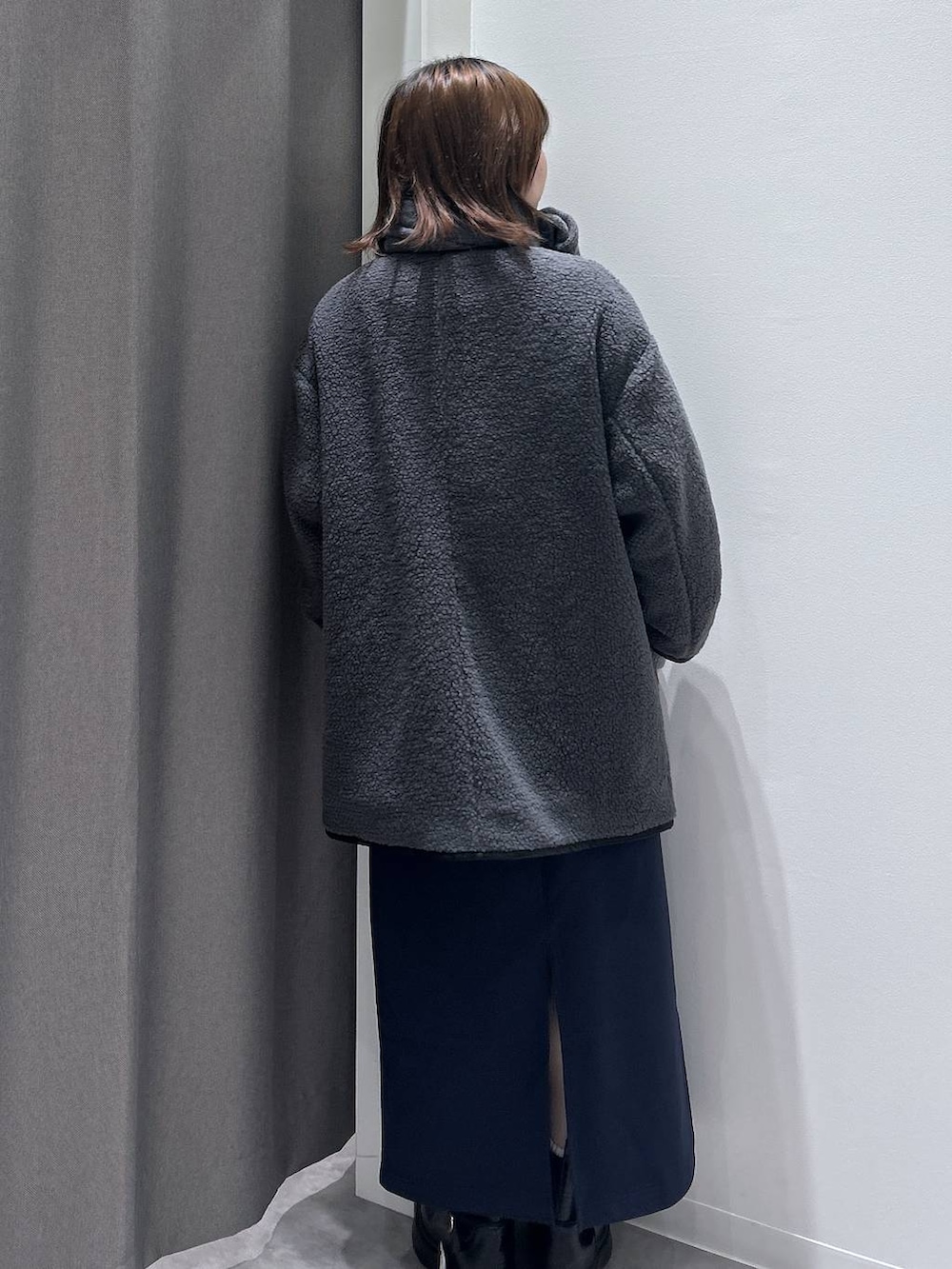 グレー系のブルゾン、ブラック系のハンドバッグ、ブラック系のブーツを着用したレディースの秋コーディネートの4枚目の写真