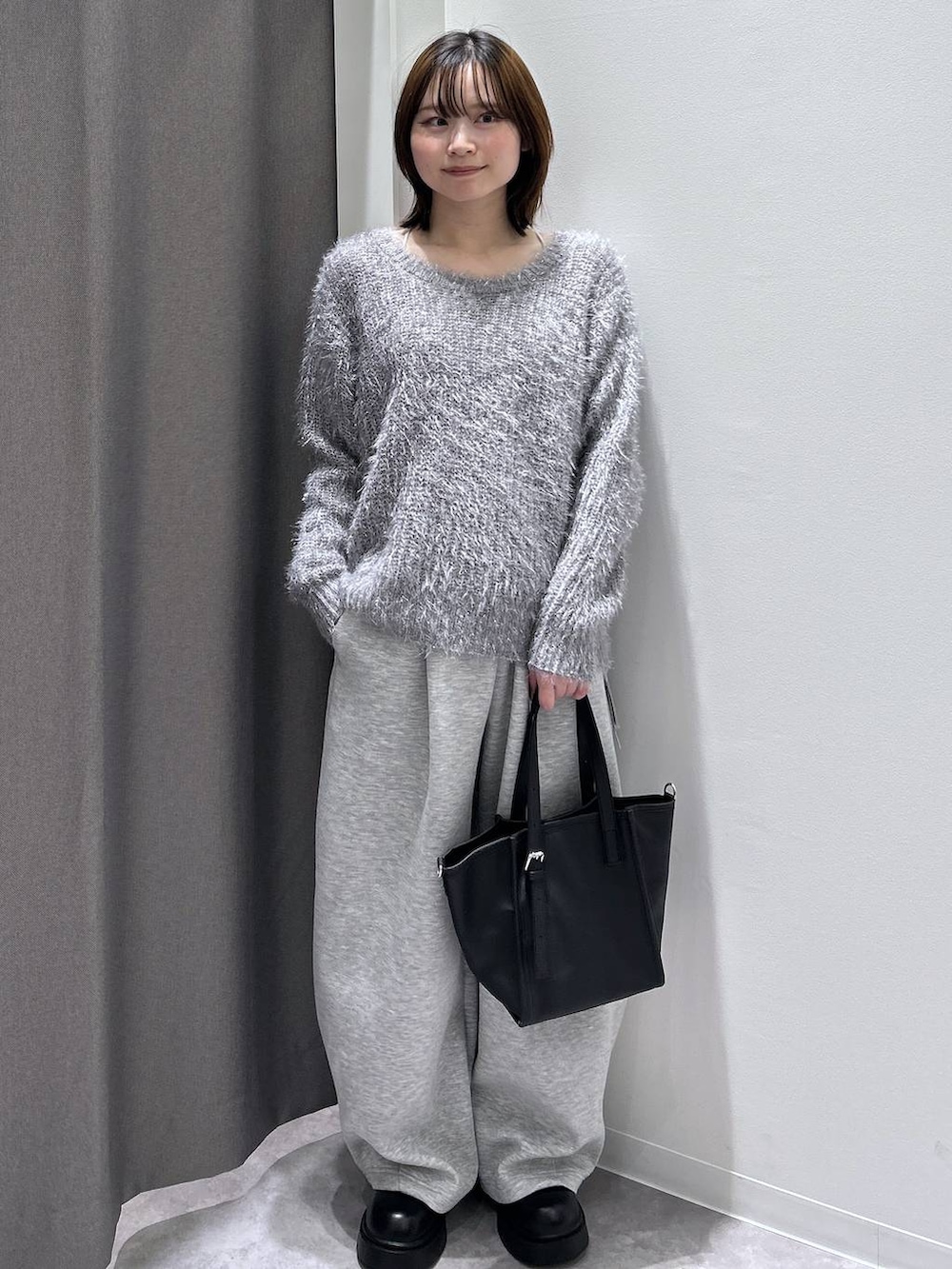 グレー系のその他アウター、ブラック系のブーツ、グレー系のスウェットパンツを着用したレディースの秋コーディネートの2枚目の写真