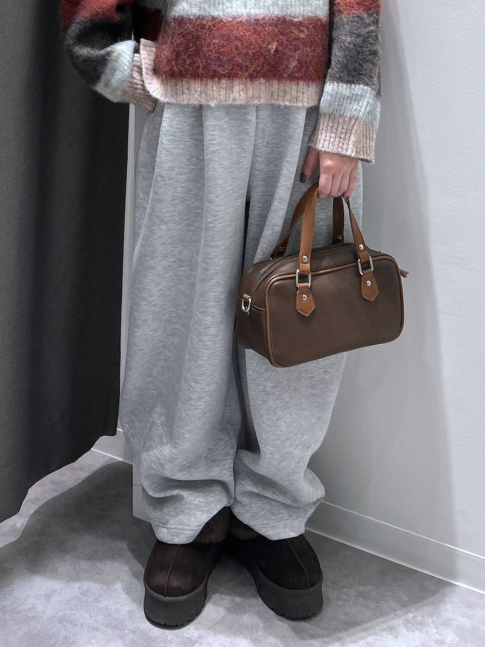 ブラウン系のスリッポン、グレー系のスウェットパンツ、ブラウン系のショルダーバッグを着用したレディースの秋コーディネートの6枚目の写真