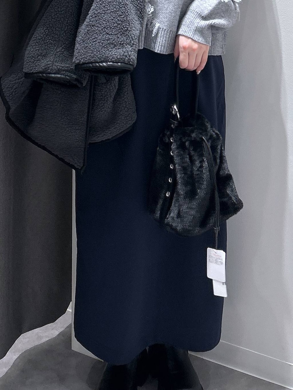 グレー系のブルゾン、ブラック系のハンドバッグ、ブラック系のブーツを着用したレディースの秋コーディネートの6枚目の写真