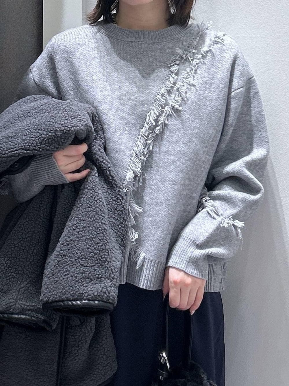 グレー系のブルゾン、ブラック系のハンドバッグ、ブラック系のブーツを着用したレディースの秋コーディネートの5枚目の写真