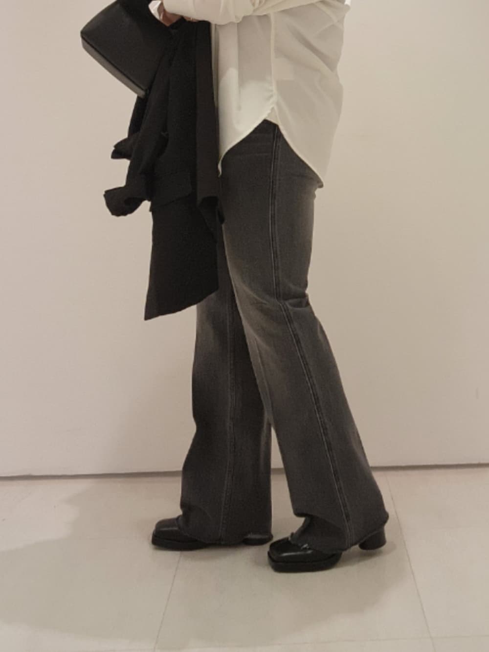 ブラック系のベスト、ホワイト系のシャツ/ブラウス、ブラック系のデニムパンツを着用したレディースの秋コーディネートの6枚目の写真