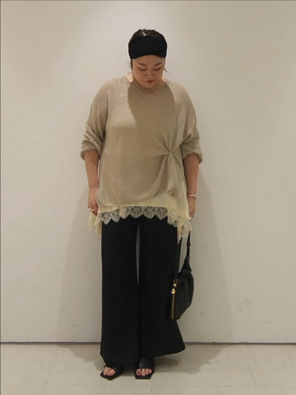 ベージュ系のニット/セーター、ホワイト系のキャミソール、ブラック系のその他パンツを着用したレディースの夏コーディネートの2枚目の写真