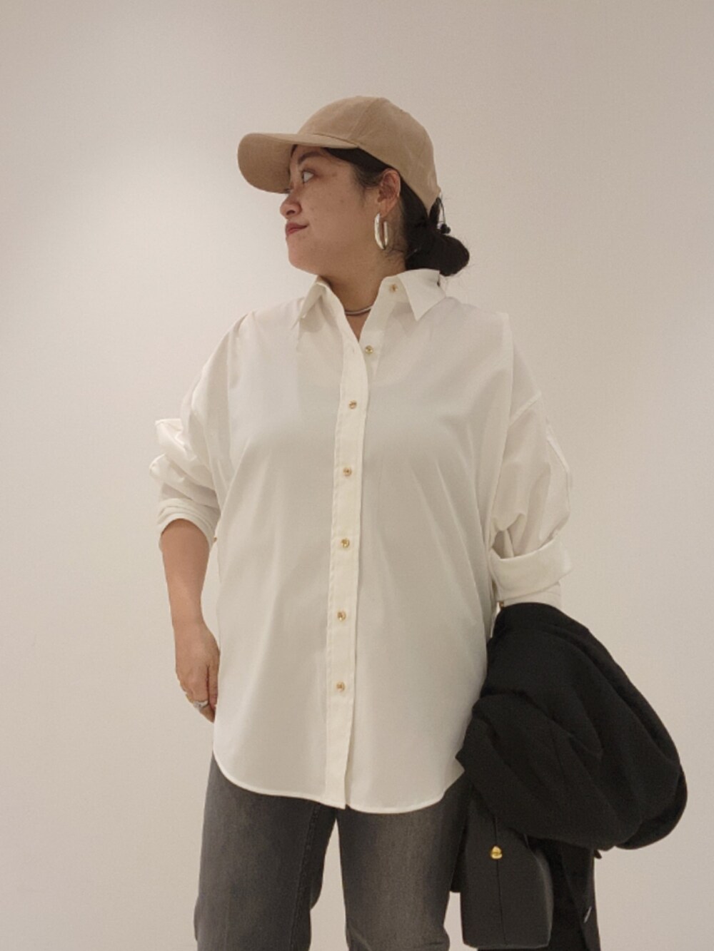 ブラック系のベスト、ホワイト系のシャツ/ブラウス、ブラック系のデニムパンツを着用したレディースの秋コーディネートの4枚目の写真