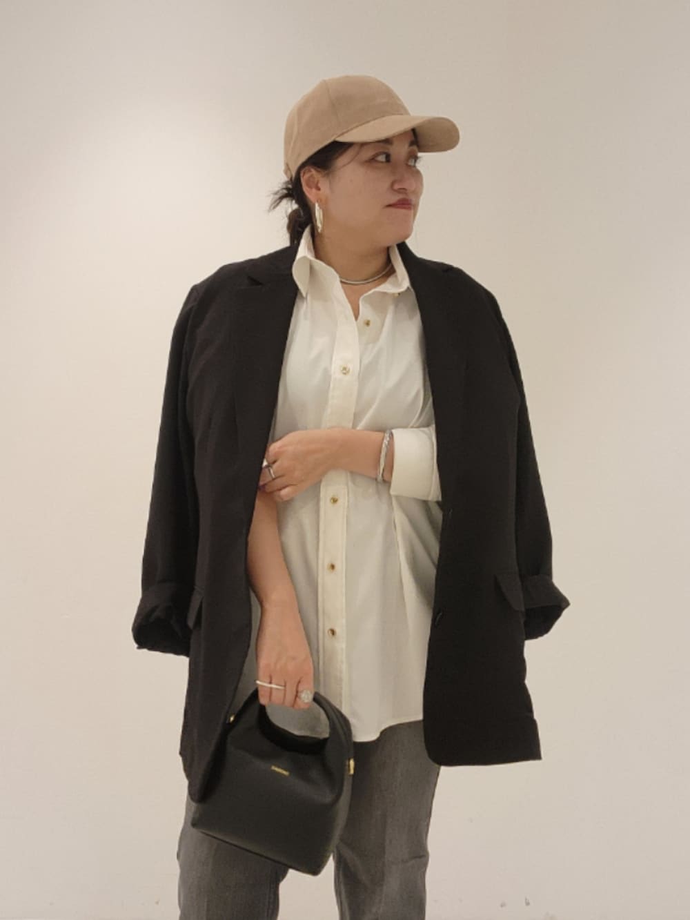 ブラック系のベスト、ホワイト系のシャツ/ブラウス、ブラック系のデニムパンツを着用したレディースの秋コーディネートの3枚目の写真