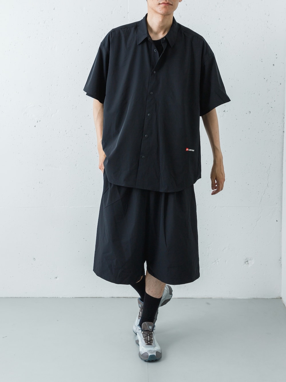 シルバー系のスニーカー、ブラック系のその他パンツ、ブラック系のシャツ/ブラウスを着用したメンズの春コーディネートの2枚目の写真