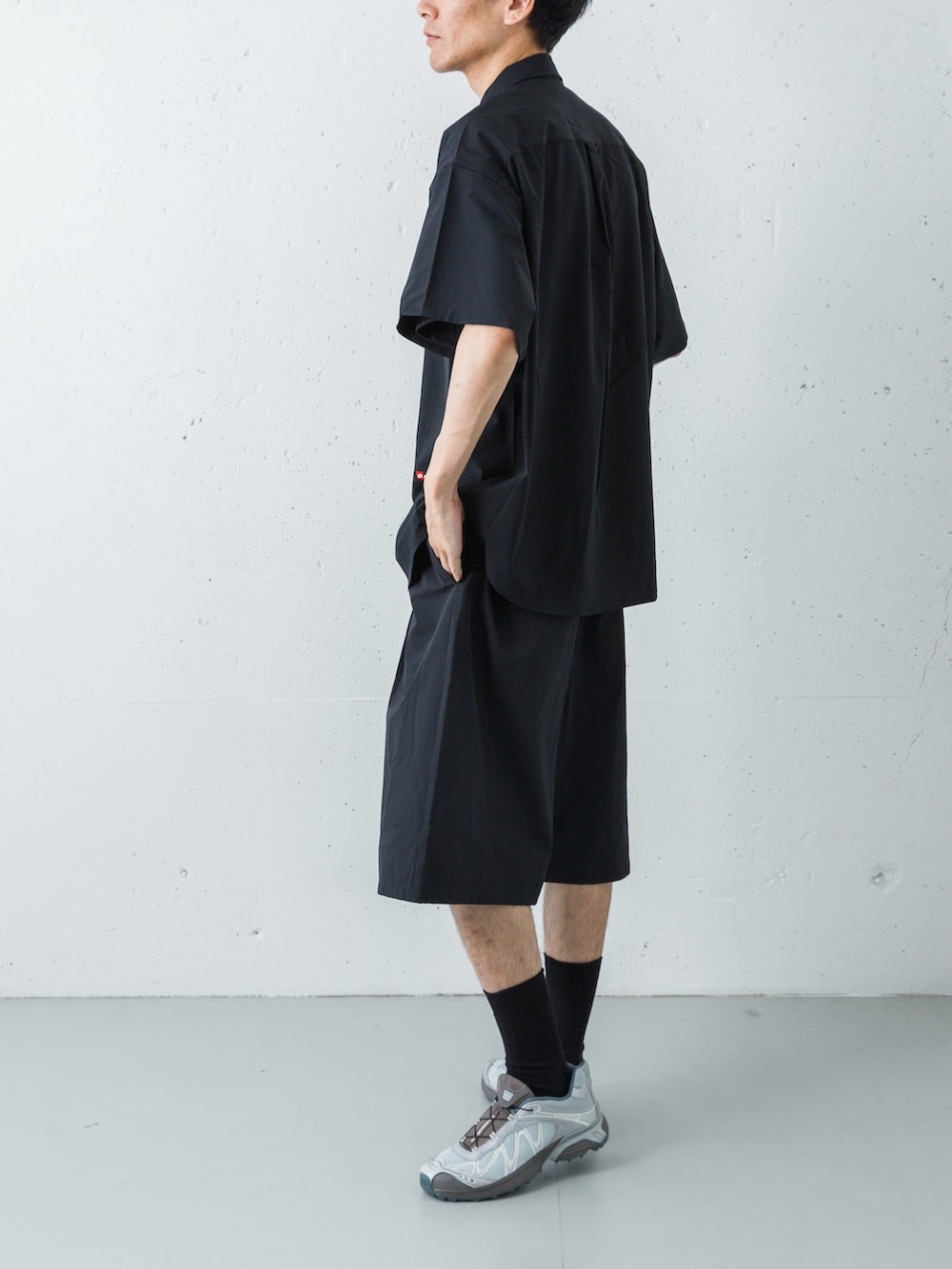 シルバー系のスニーカー、ブラック系のその他パンツ、ブラック系のシャツ/ブラウスを着用したメンズの春コーディネートの4枚目の写真