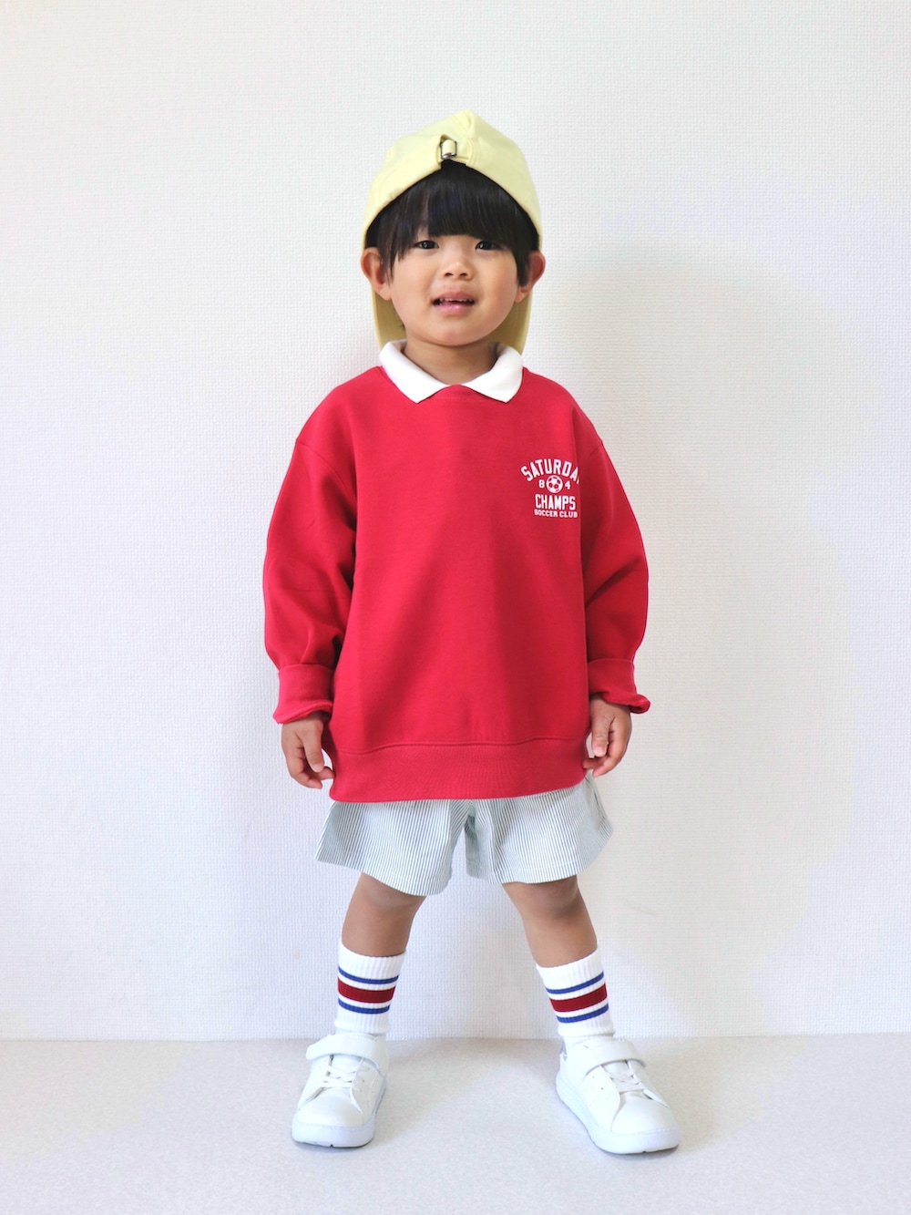 レッド系のスウェット、その他のデニムパンツを着用したキッズの春コーディネートの2枚目の写真