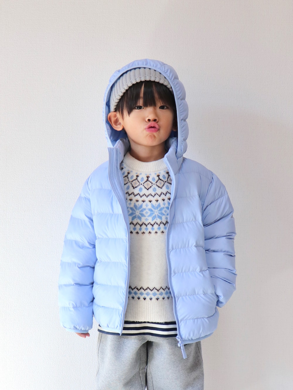 ブルー系のダウンジャケット/コート、ホワイト系のニット/セーター、その他のTシャツ/カットソーを着用したキッズの春コーディネートの2枚目の写真