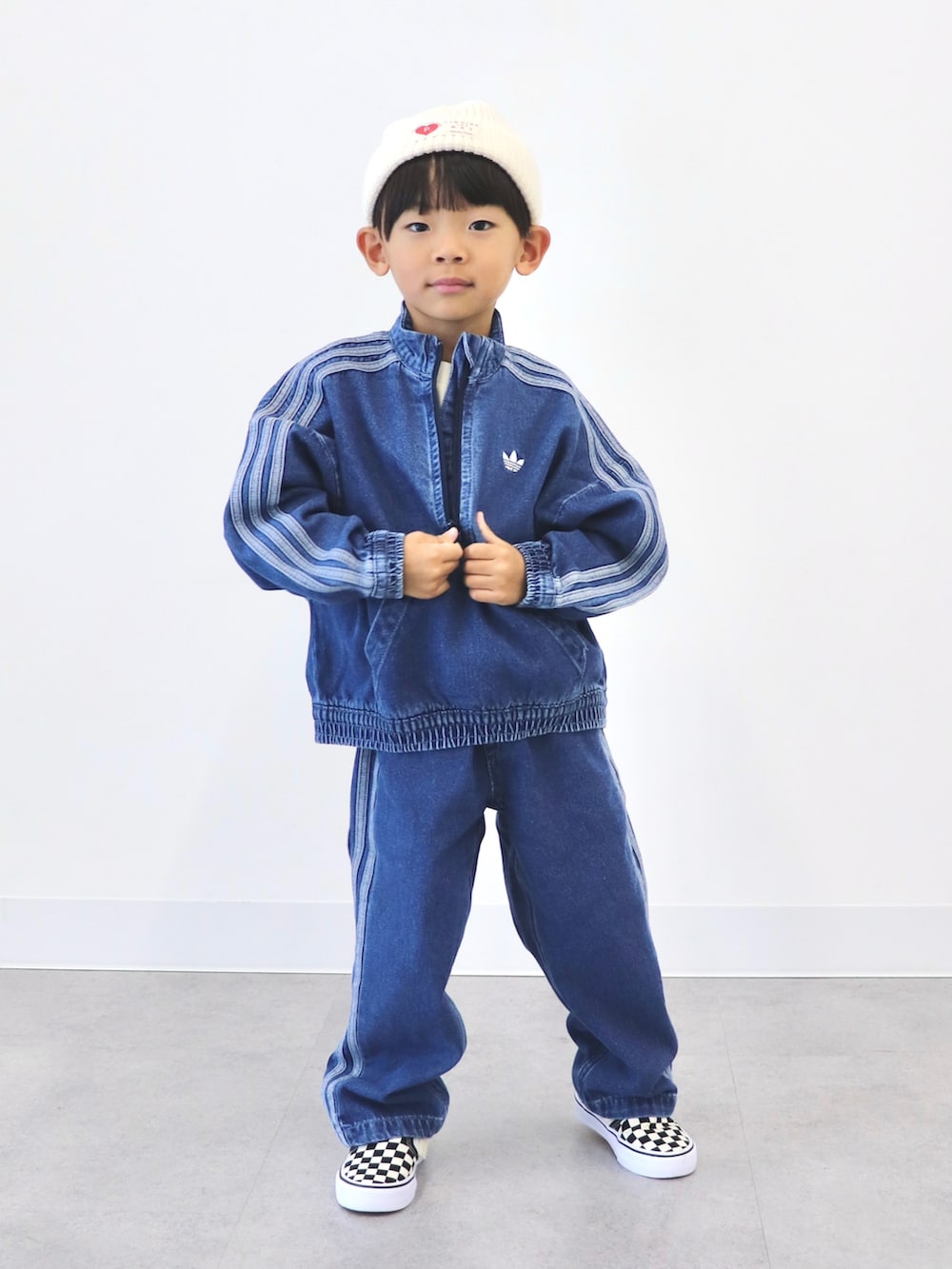 ブルー系のジャージ、ブラック系のスリッポン、ホワイト系のニットキャップ/ビーニーを着用したキッズの冬コーディネートの2枚目の写真