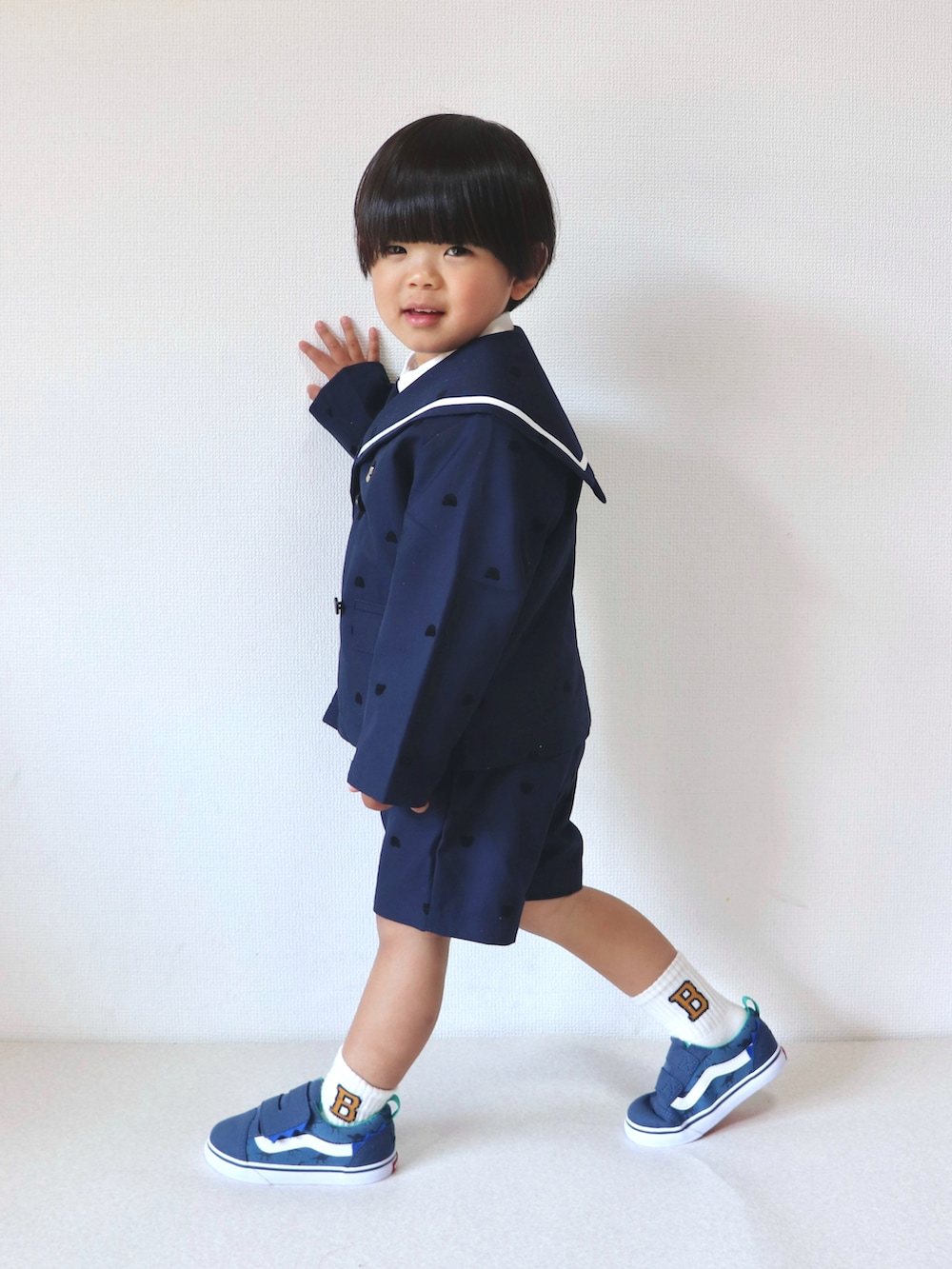 ブルー系のスーツジャケット、ブルー系のスーツパンツ、ブルー系のスニーカーを着用したキッズの春コーディネートの2枚目の写真