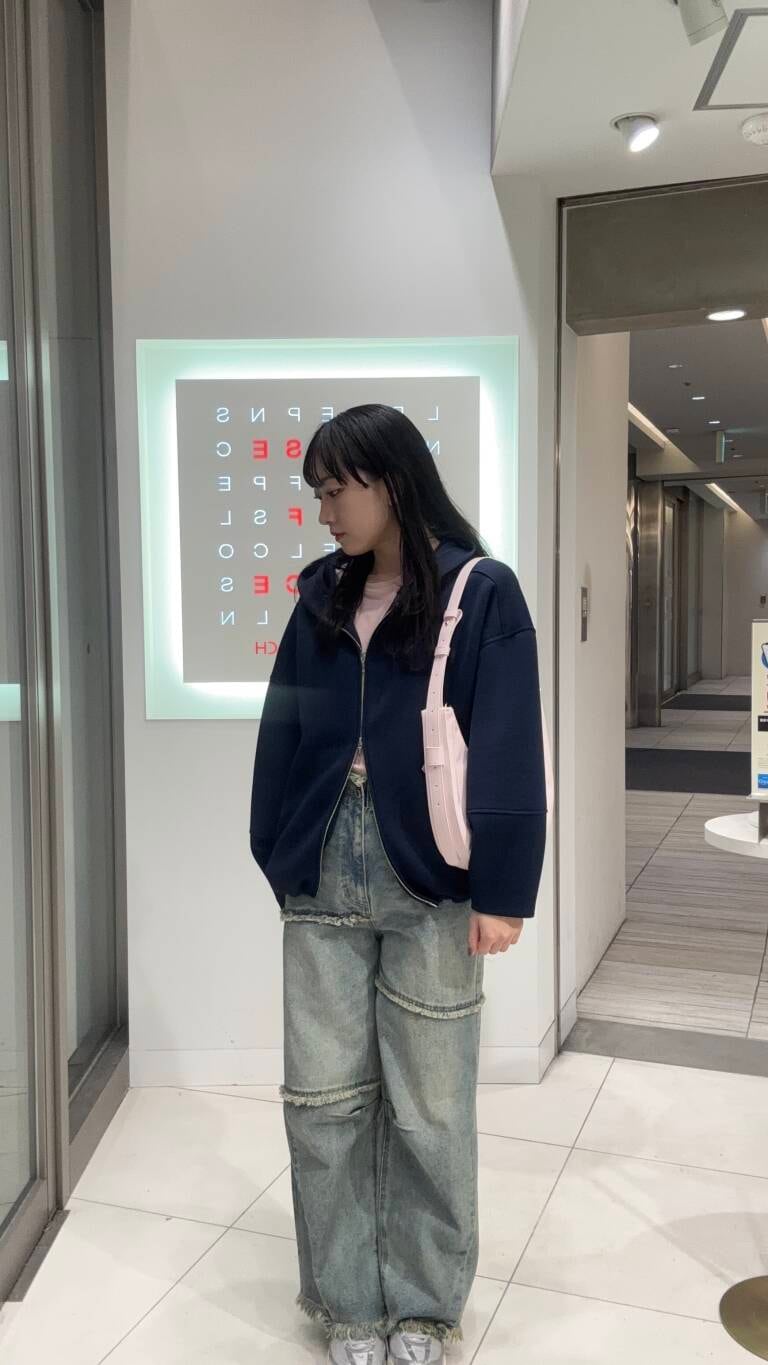 ピンク系のTシャツ/カットソー、ブルー系のデニムパンツ、ピンク系のショルダーバッグを着用したレディースの冬コーディネートの2枚目の写真