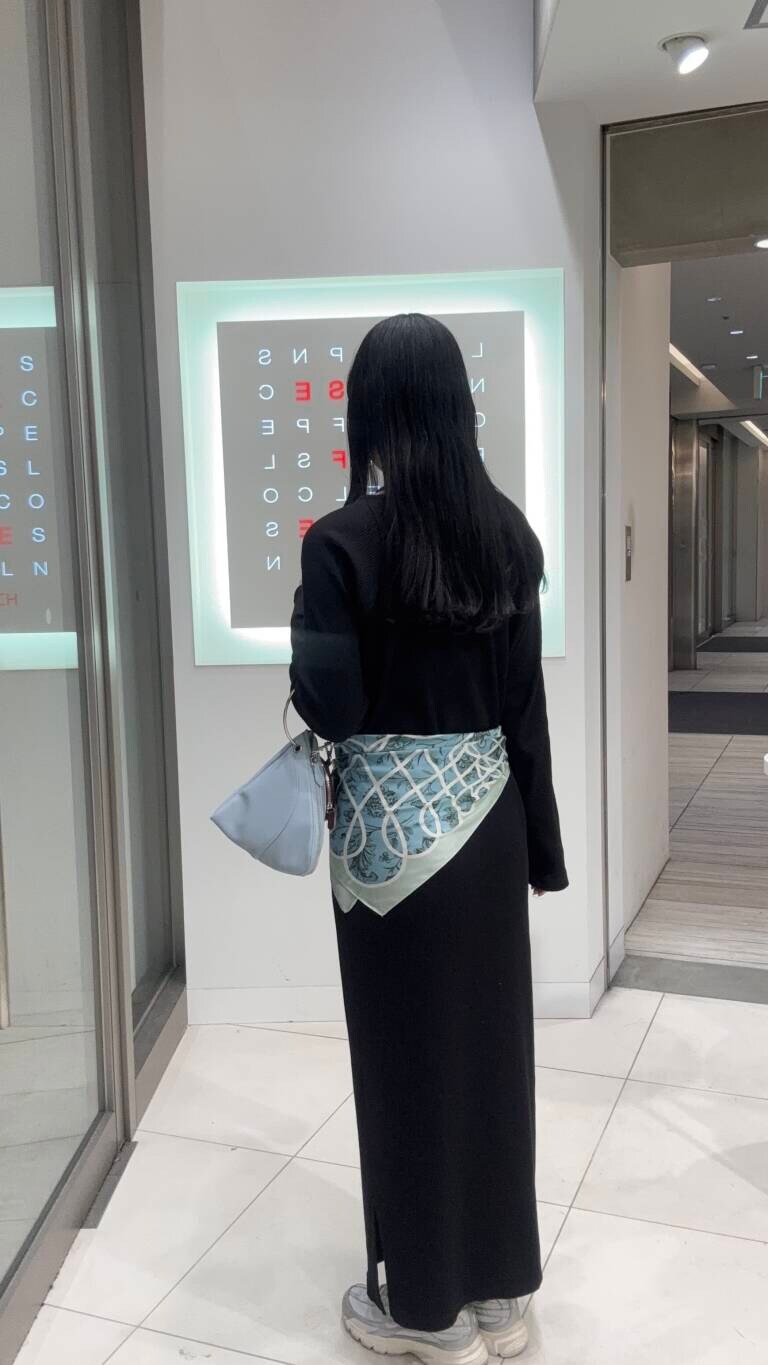 ブルー系のハンドバッグ、ブラック系のワンピースを着用したレディースの冬コーディネートの3枚目の写真