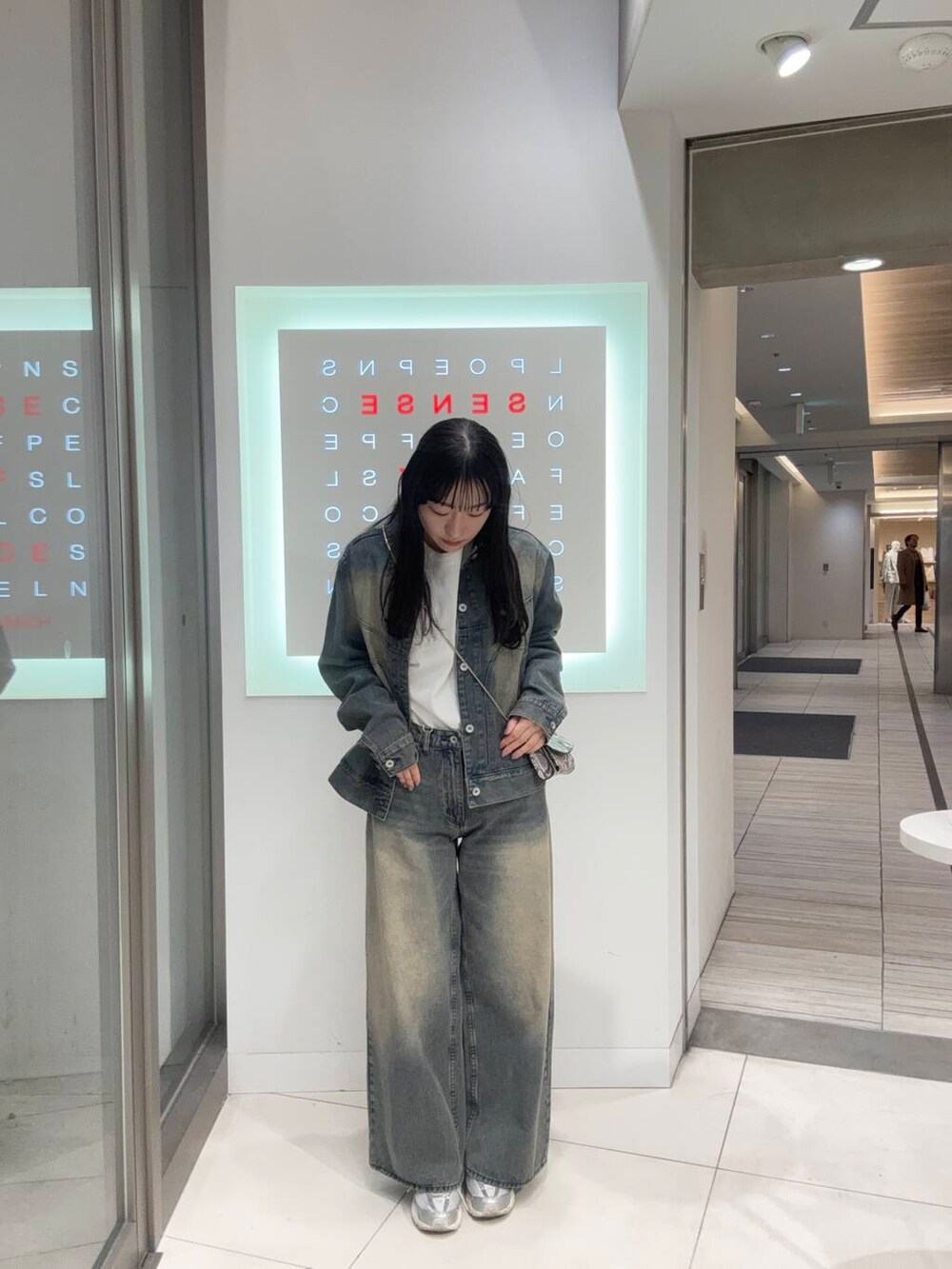 ブルー系のデニムジャケット、ブルー系のデニムパンツ、ホワイト系のTシャツ/カットソーを着用したレディースの冬コーディネートの2枚目の写真