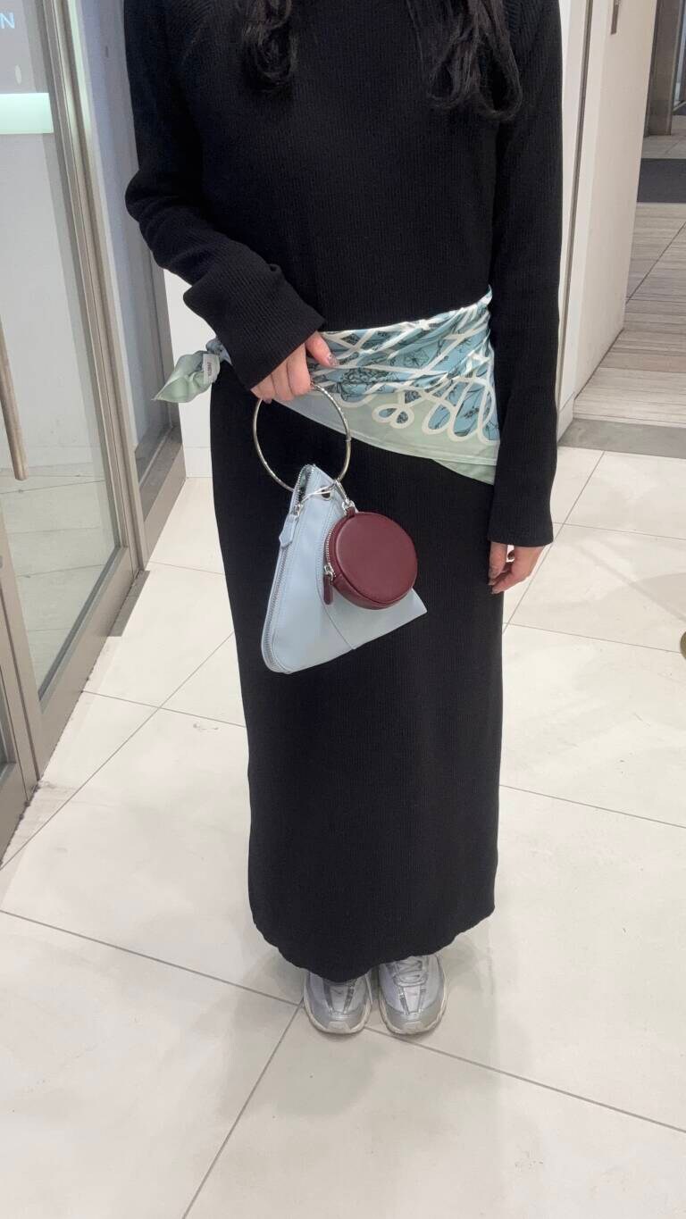 ブルー系のハンドバッグ、ブラック系のワンピースを着用したレディースの冬コーディネートの4枚目の写真