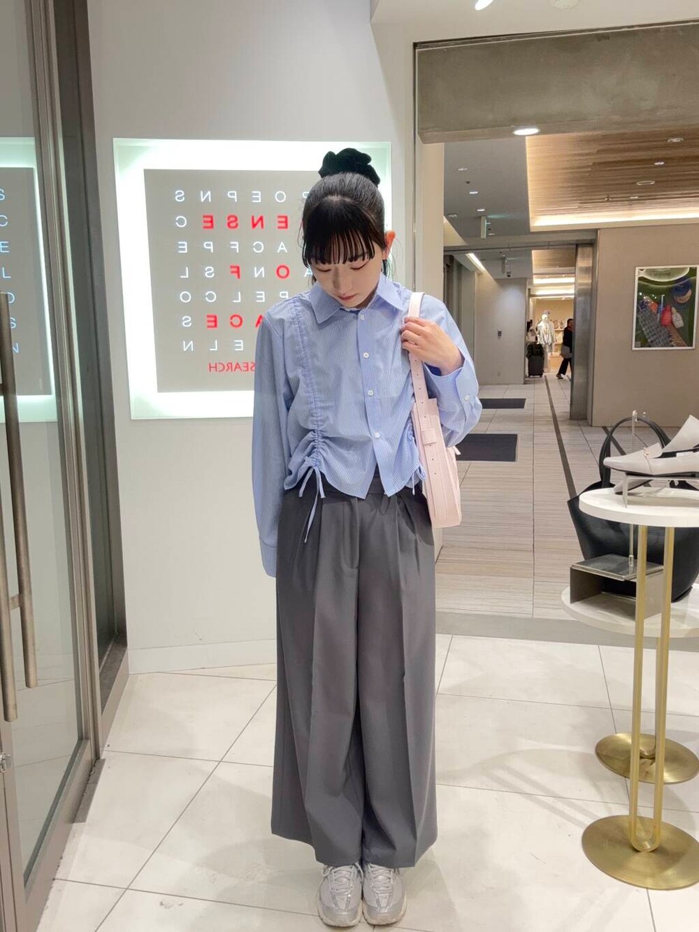 ピンク系のショルダーバッグ、グレー系のその他パンツ、ブルー系のシャツ/ブラウスを着用したレディースの春コーディネートの2枚目の写真