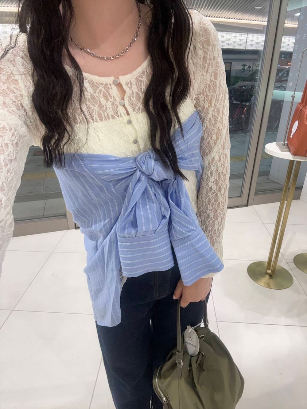 ブルー系のデニムパンツ、ブラック系のパンプス、ホワイト系のキャミソールを着用したレディースの春コーディネートの3枚目の写真