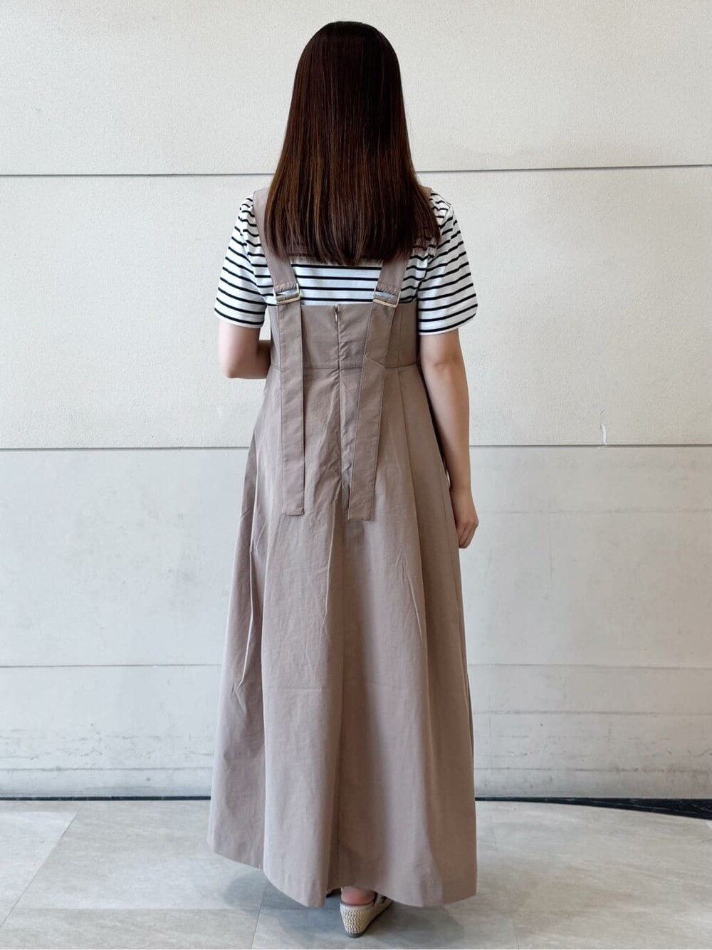 ホワイト系のTシャツ/カットソー、イエロー系のワンピース、ベージュ系のハットを着用したレディースの春コーディネートの4枚目の写真