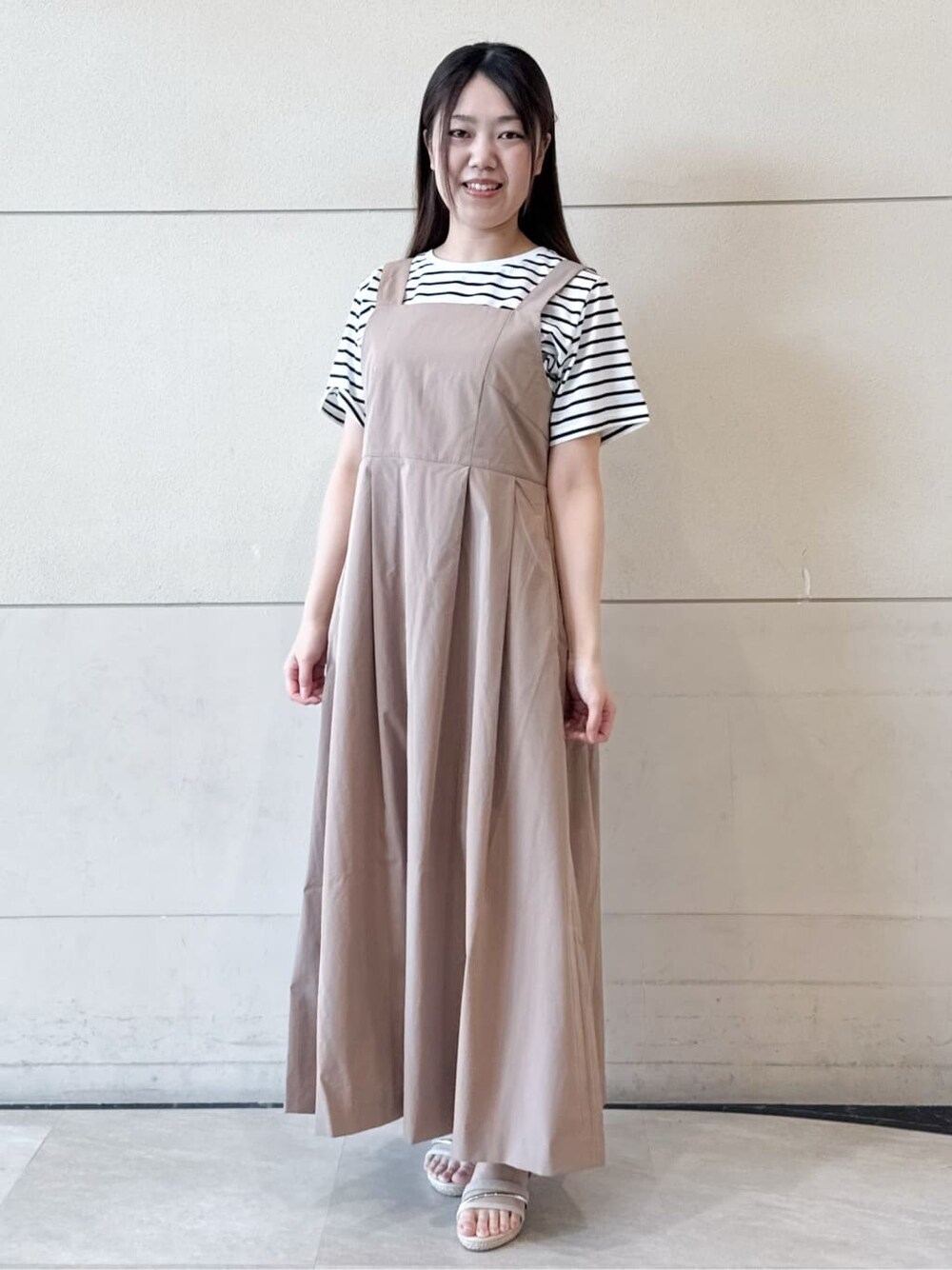 ホワイト系のTシャツ/カットソー、イエロー系のワンピース、ベージュ系のハットを着用したレディースの春コーディネートの2枚目の写真