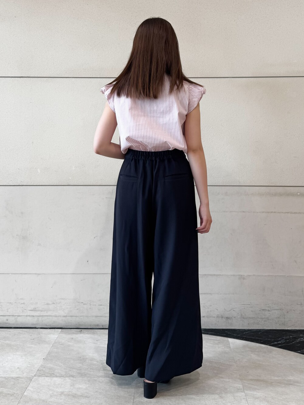 ピンク系のシャツ/ブラウス、ブルー系のその他パンツ、ブラック系のサンダルを着用したレディースの夏コーディネートの3枚目の写真