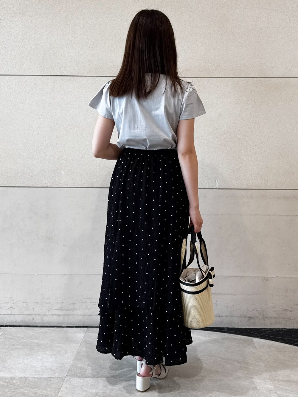 グレー系のTシャツ/カットソー、ブラック系のスカート、ホワイト系のトートバッグを着用したレディースの夏コーディネートの3枚目の写真